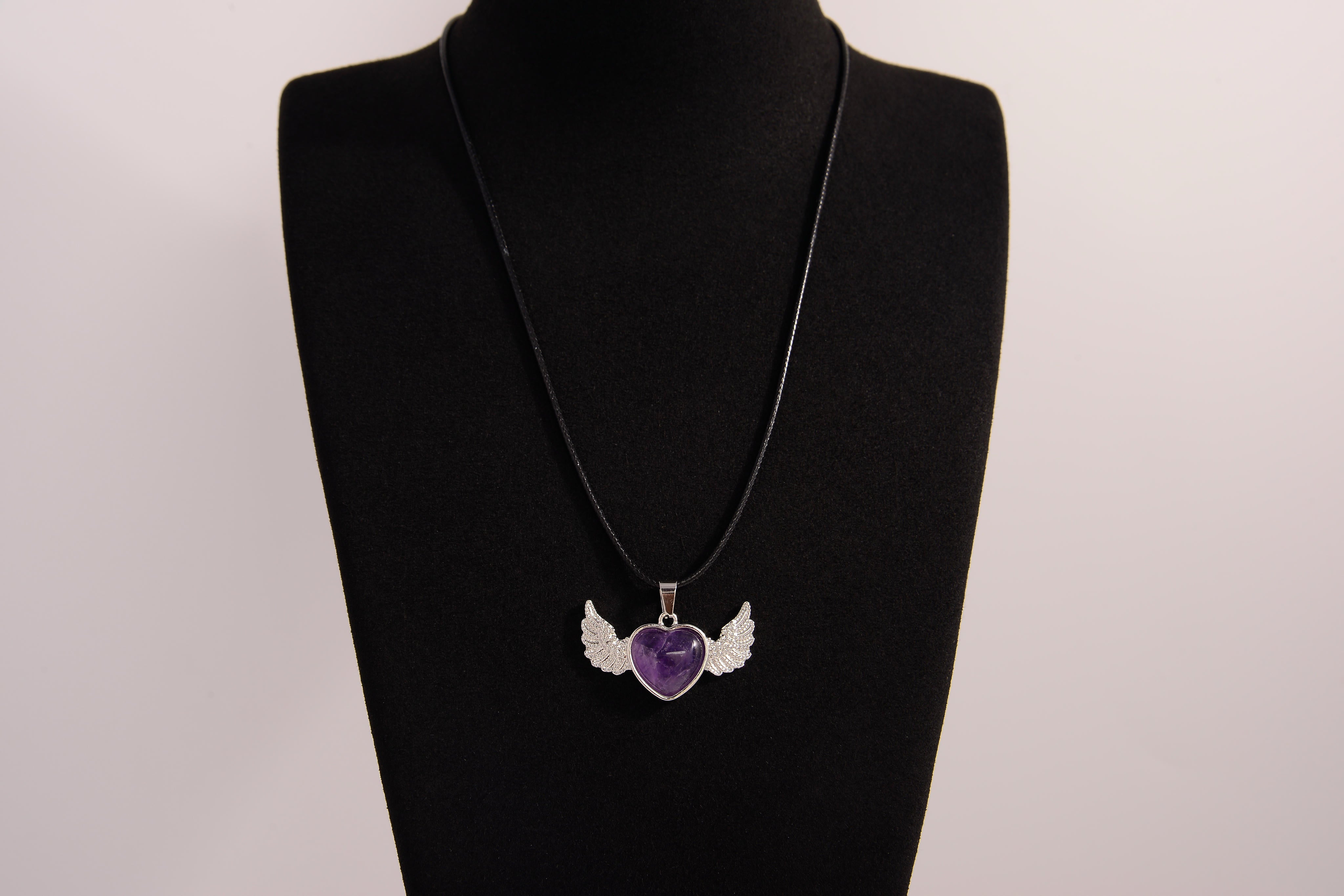 Raw Earth Crystals amethyst heart with wings necklace, featuring a deep purple heart-shaped stone adorned with delicate angelic wings, designed to enhance intuition, promote spiritual growth, and support inner peace.