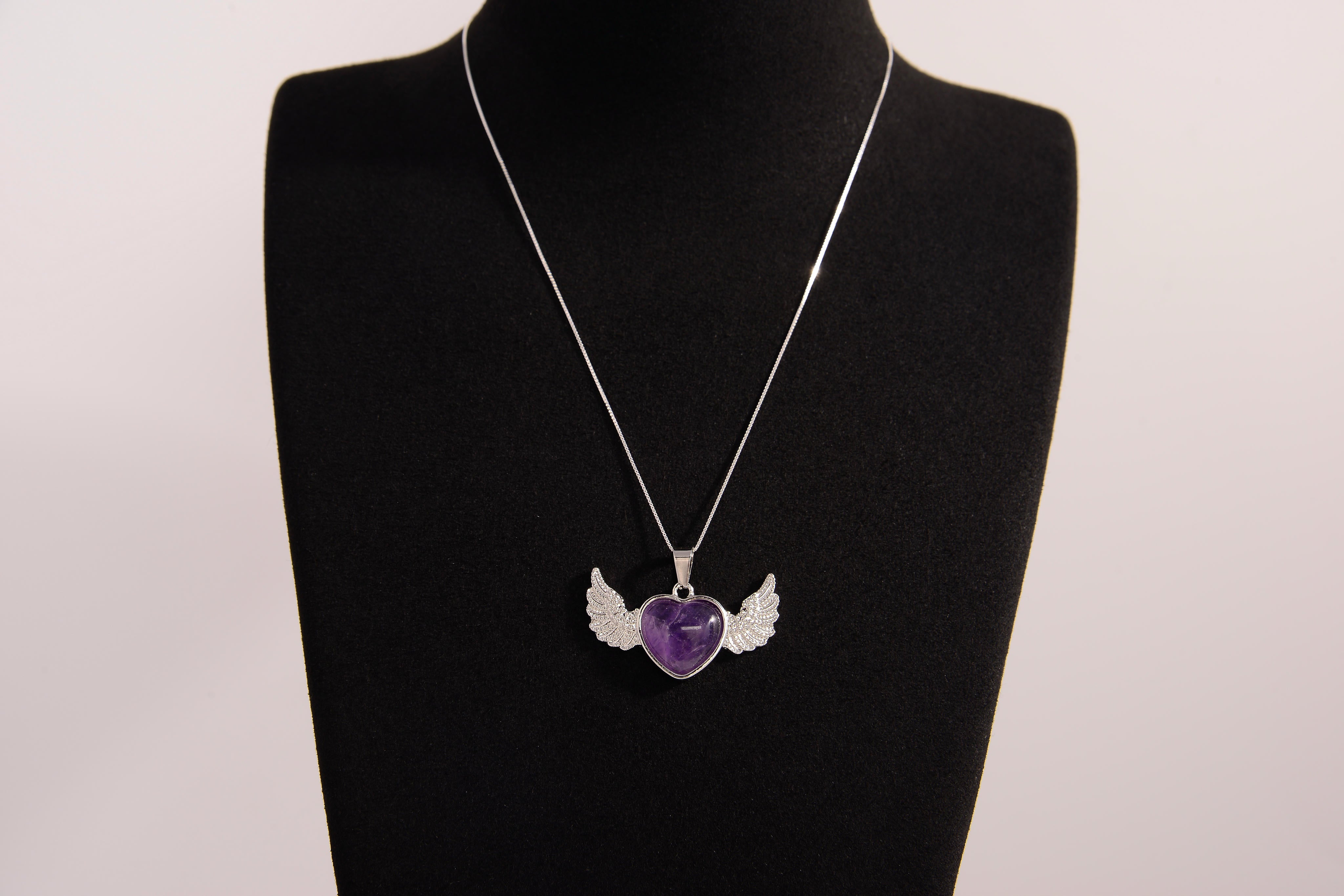Raw Earth Crystals amethyst heart with wings necklace, featuring a deep purple heart-shaped stone adorned with delicate angelic wings, designed to enhance intuition, promote spiritual growth, and support inner peace.