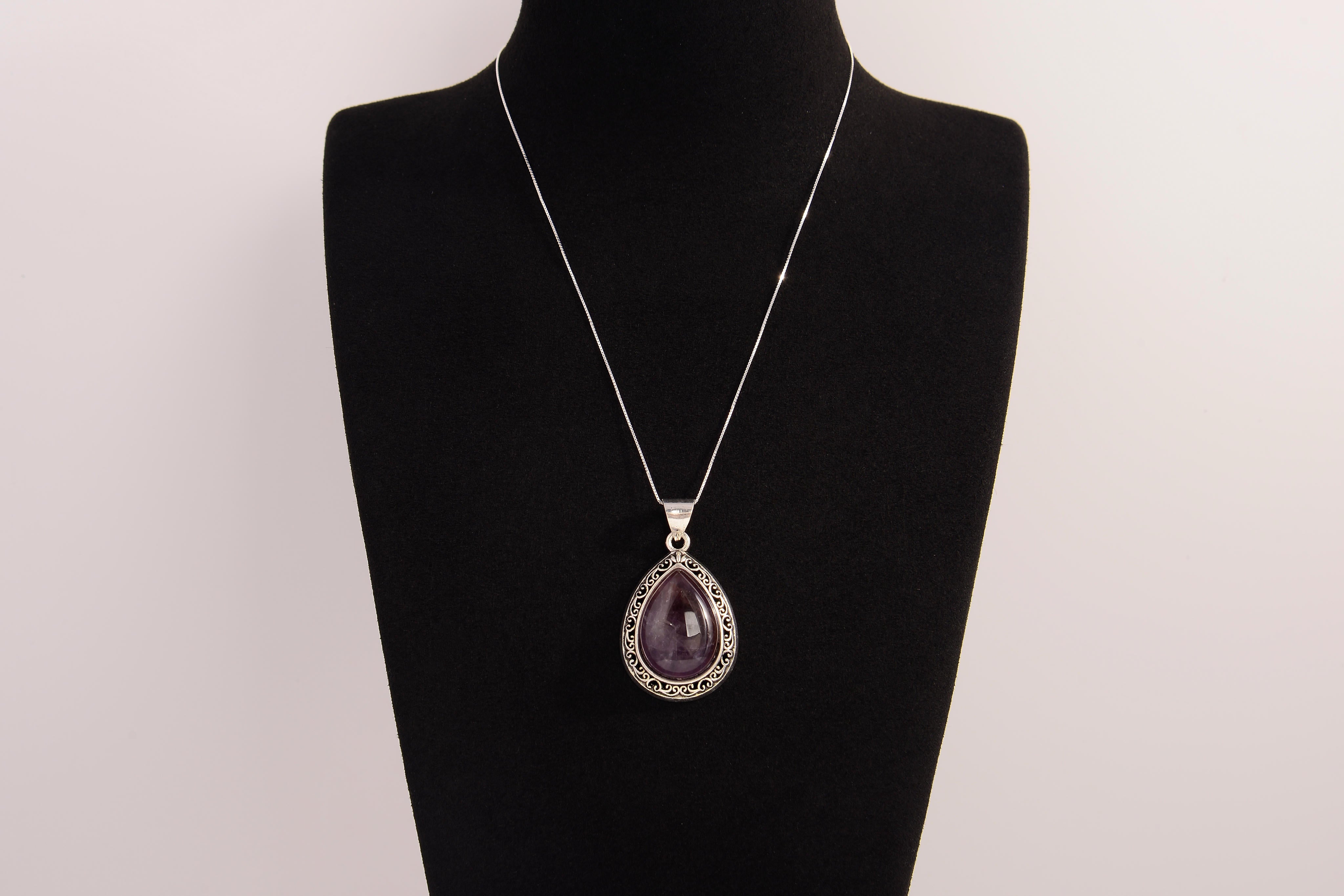 Raw Earth Crystals amethyst pendant with a teardrop-shaped design, featuring natural amethyst and an ornate silver-tone setting, promoting spiritual growth, calmness, and intuition.