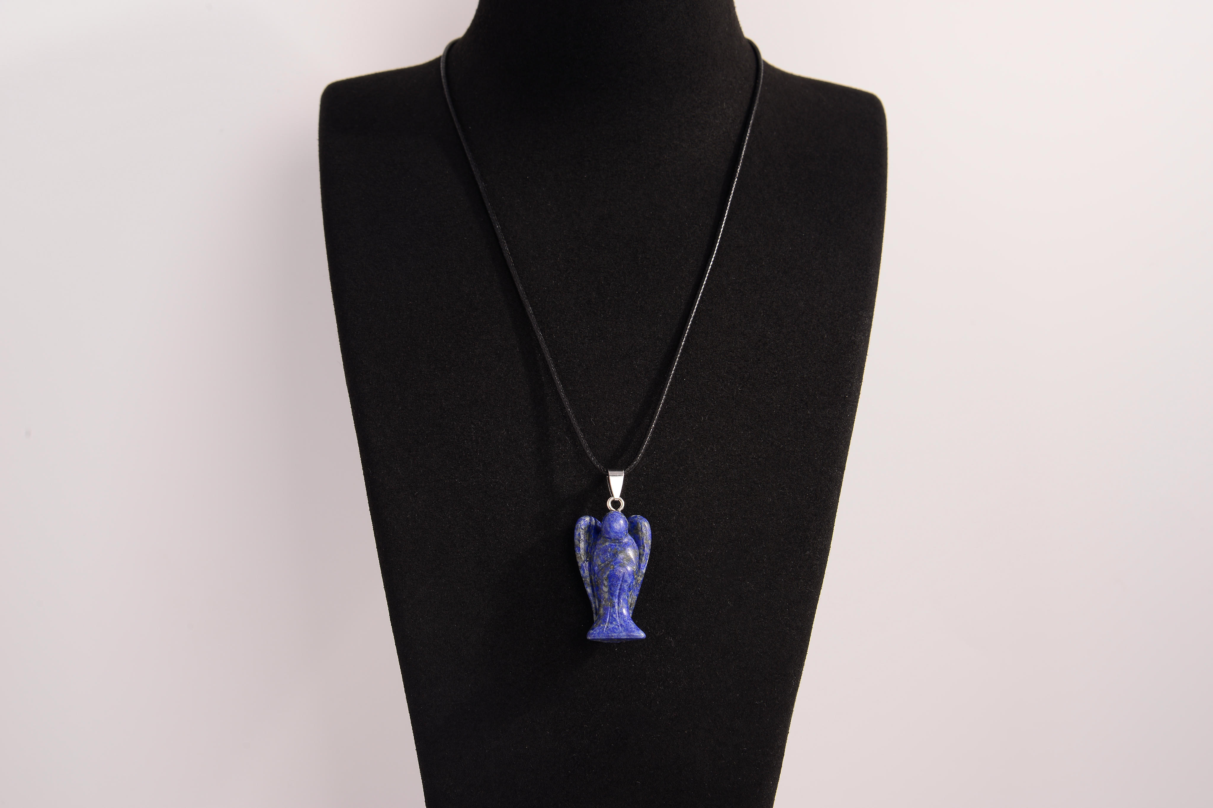 Raw Earth Crystals angel pendant crafted from carved lapis lazuli, featuring a deep blue hue with golden flecks to promote wisdom, intuition, and spiritual insight.