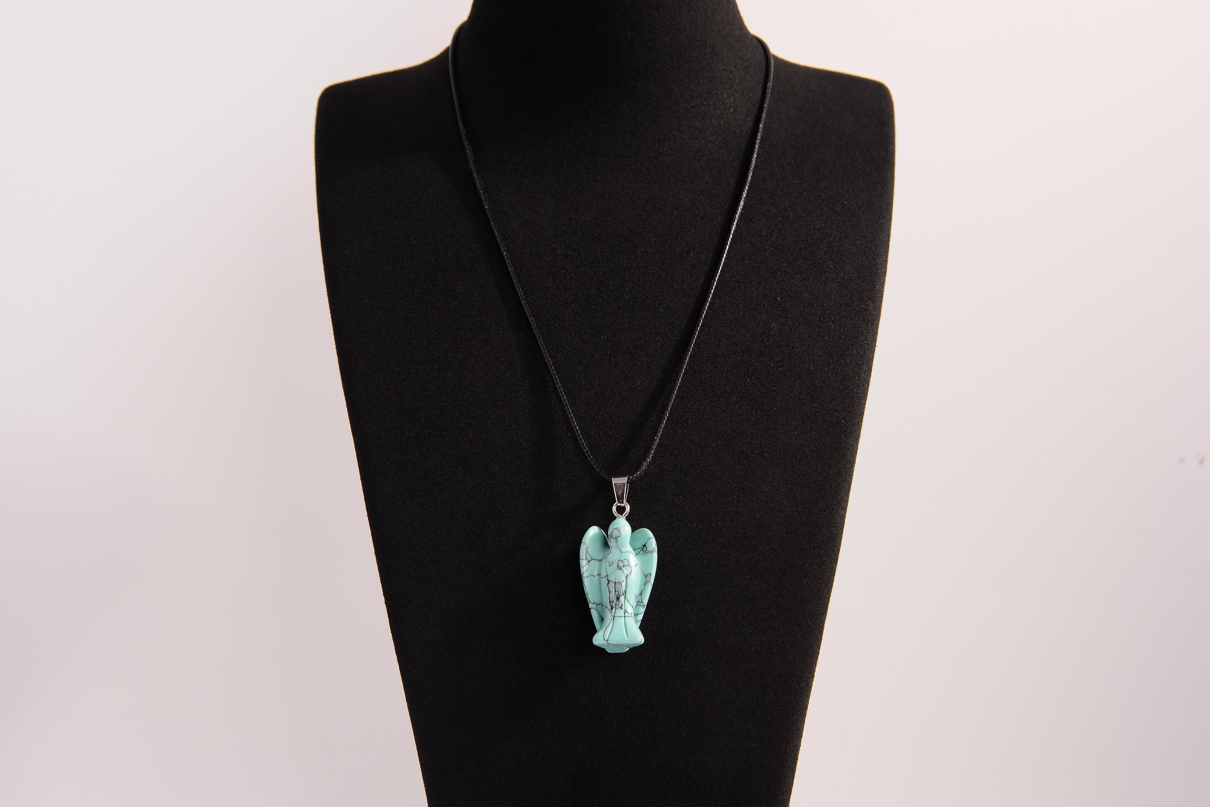 Raw Earth Crystals angel pendant crafted from carved turquoise, featuring a vibrant blue-green hue with natural matrix patterns to promote communication, protection, and emotional balance.