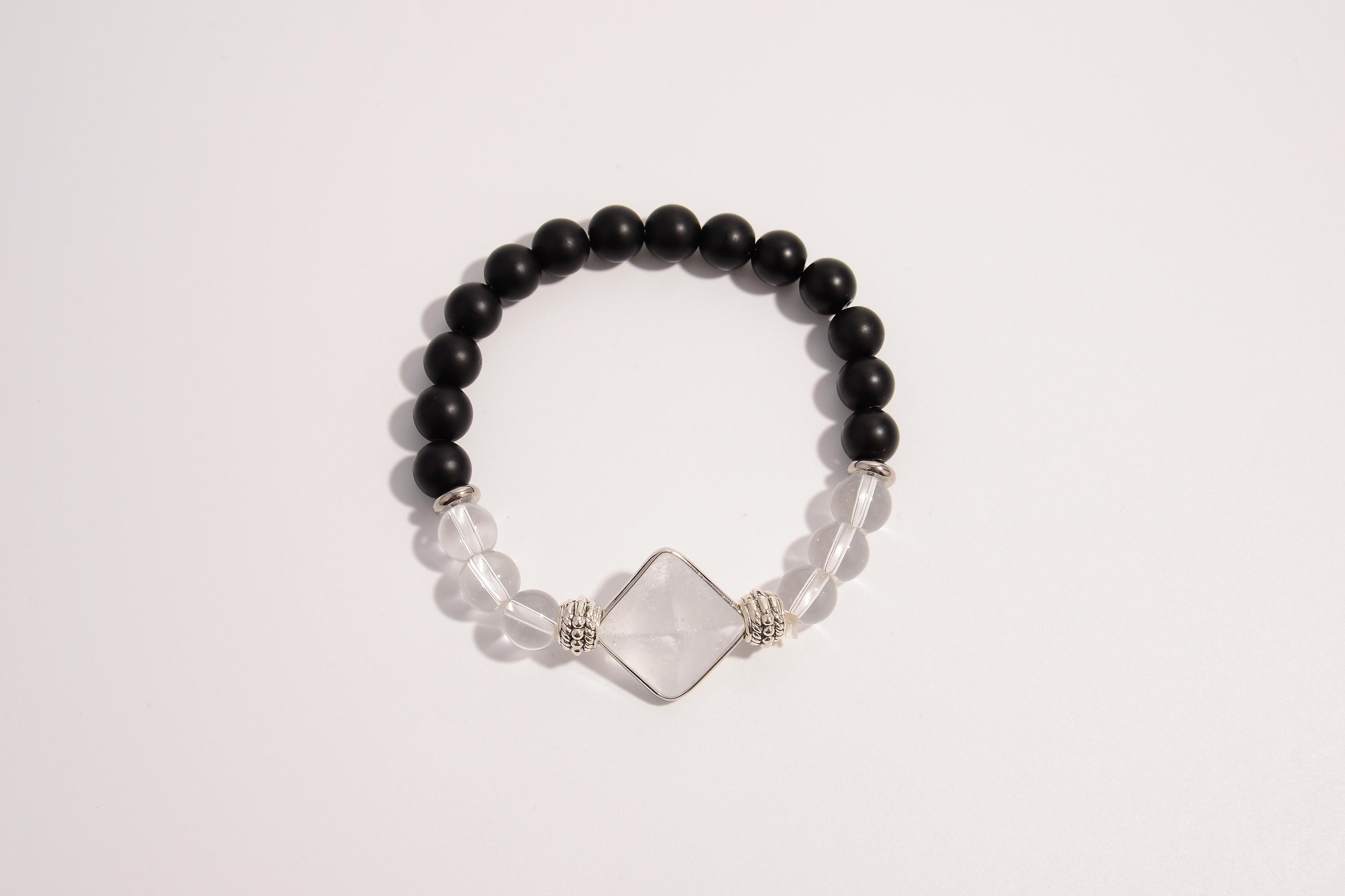 Raw Earth Crystals black onyx and clear quartz bracelet with silver accent, crafted from natural crystals, promotes clarity, protection, and spiritual alignment.