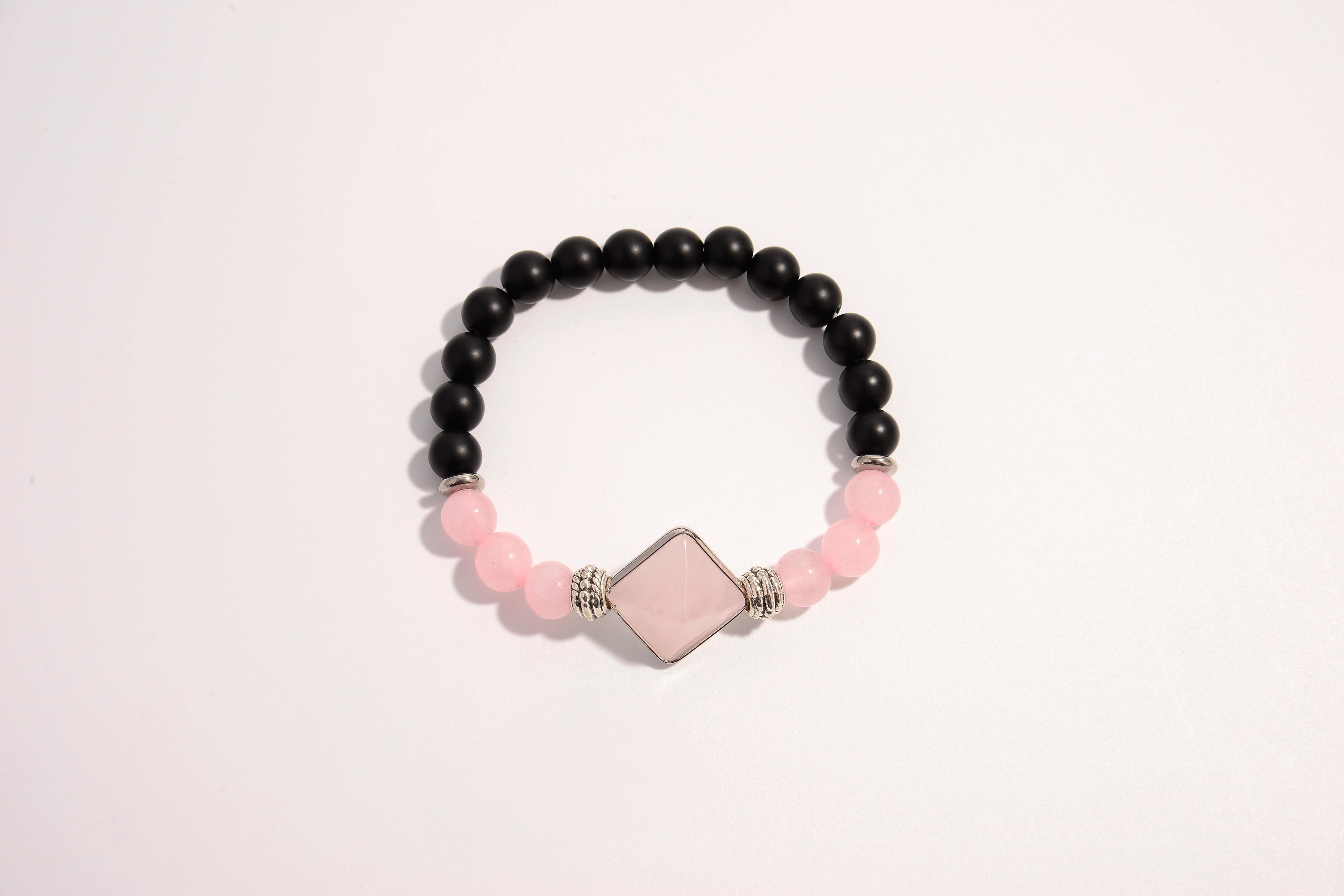 Raw Earth Crystals black onyx and pink quartz bracelet with silver accent, crafted from natural crystals, promotes emotional balance, love, and inner peace.