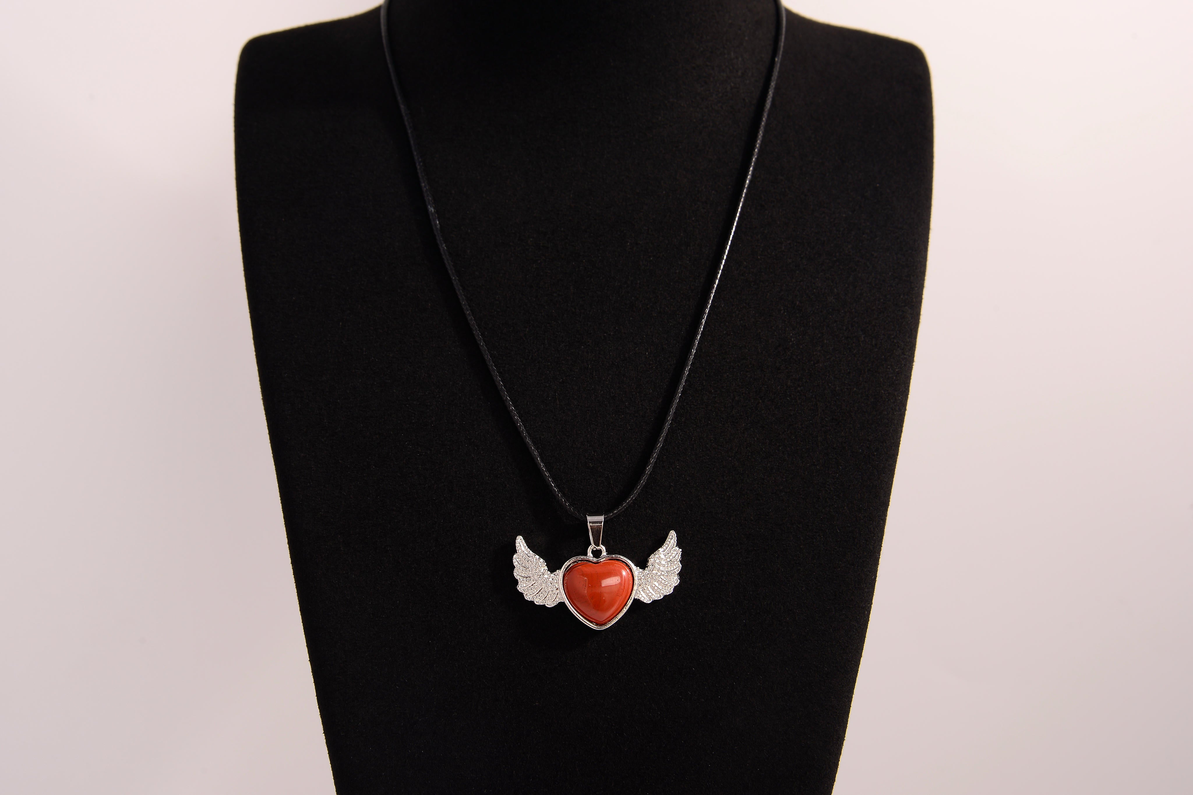 Raw Earth Crystals carnelian heart with wings necklace, featuring a vibrant orange-red heart-shaped stone adorned with delicate angelic wings, designed to boost energy, enhance motivation, and support emotional strength.