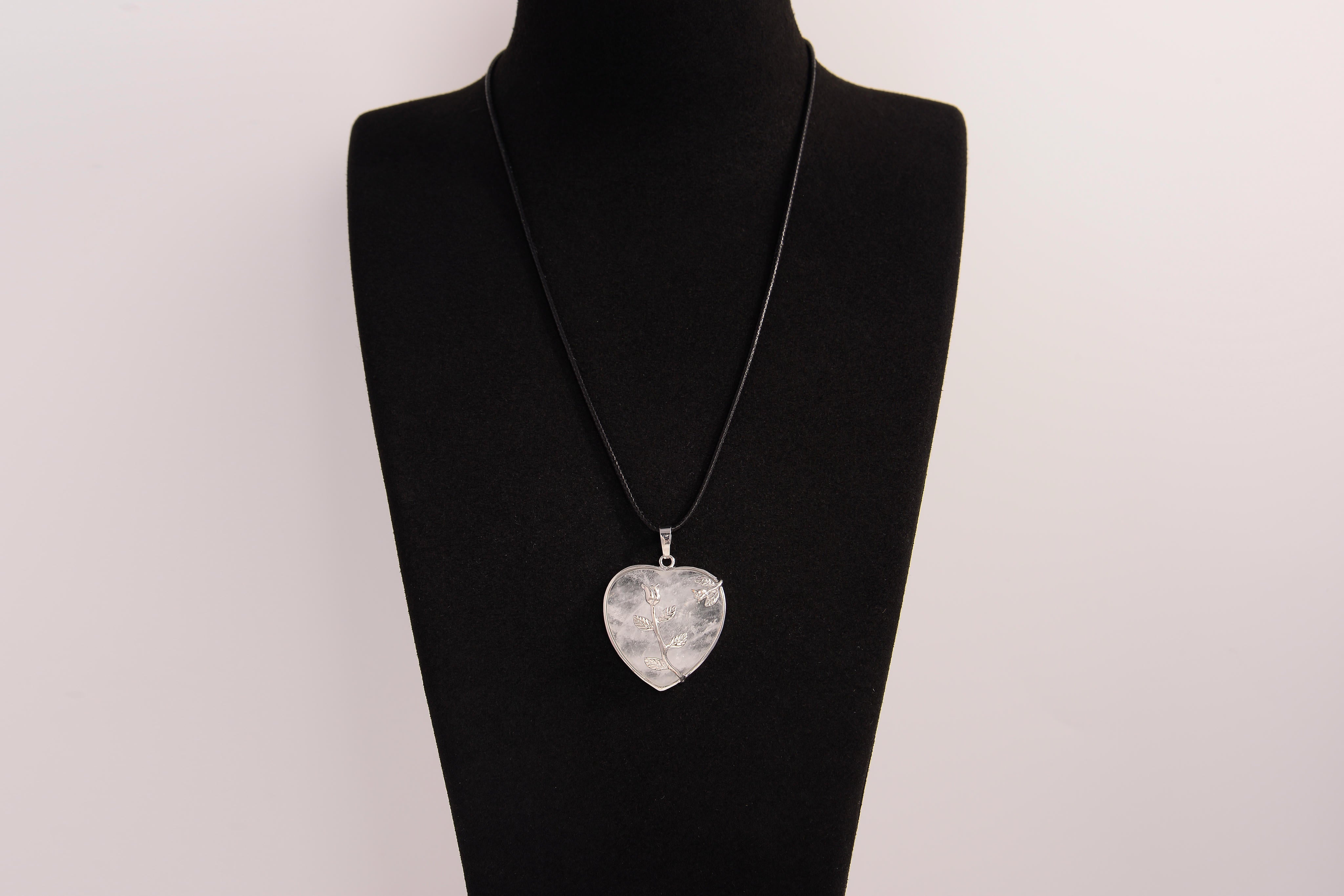 Raw Earth Crystals clear quartz heart pendant with an elegant rose design, featuring a delicate silver-tone stem and leaves embedded in natural clear quartz, promoting clarity, love, and spiritual connection.