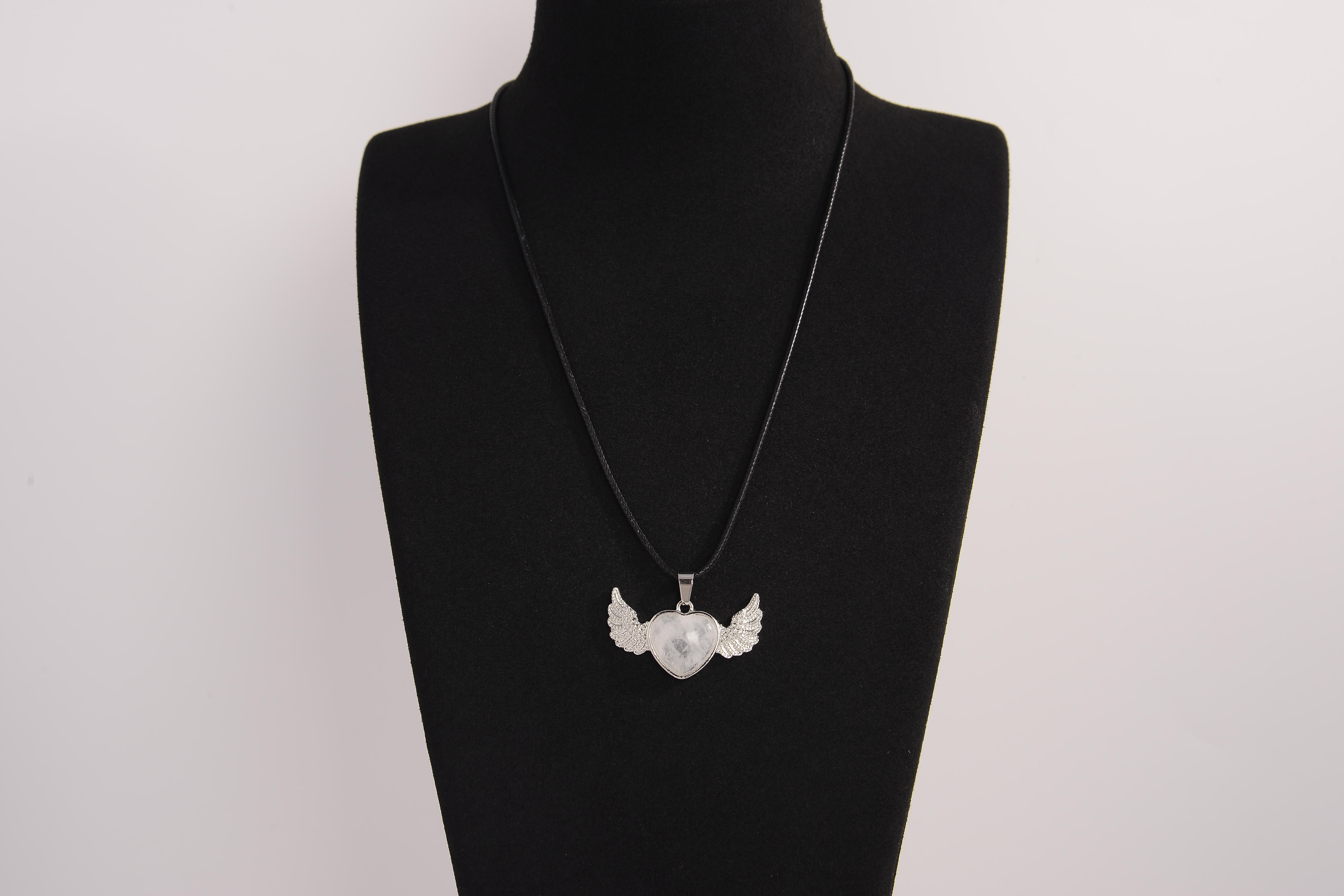 Raw Earth Crystals clear quartz heart with wings necklace, featuring a luminous heart-shaped stone adorned with angelic wings, designed to amplify energy, enhance clarity, and offer spiritual protection.