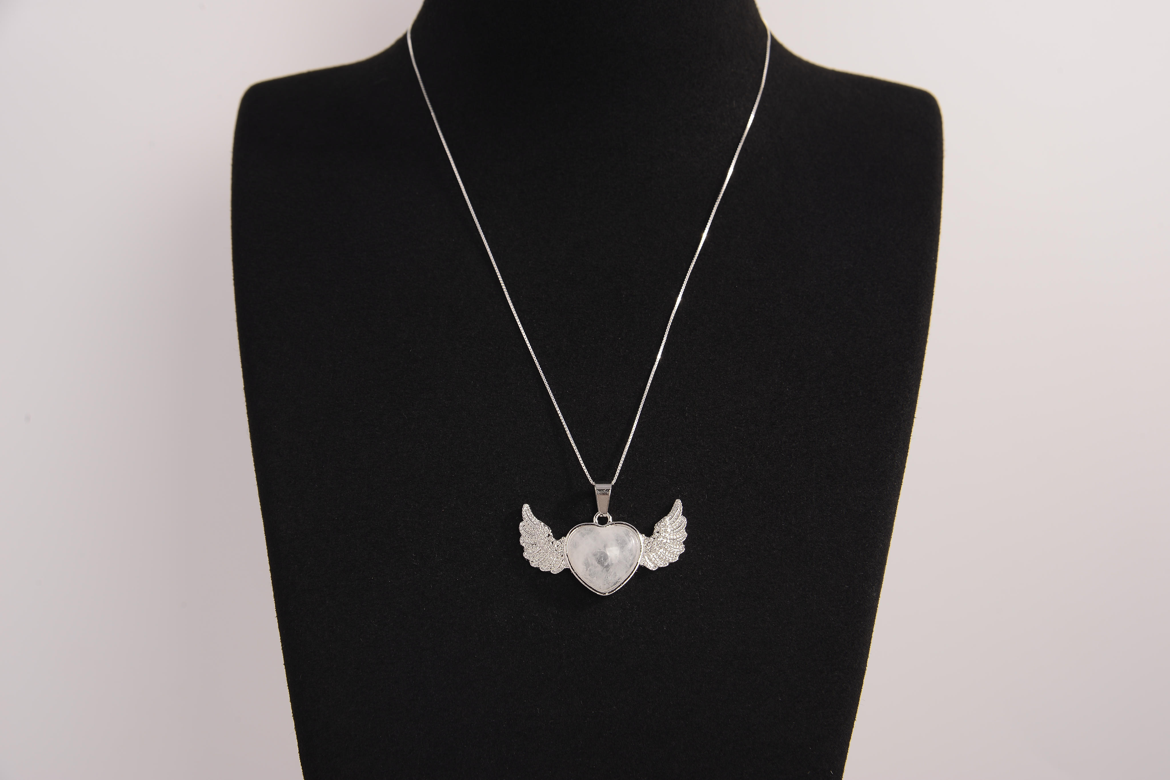 Raw Earth Crystals clear quartz heart with wings necklace, featuring a luminous heart-shaped stone adorned with angelic wings, designed to amplify energy, enhance clarity, and offer spiritual protection.