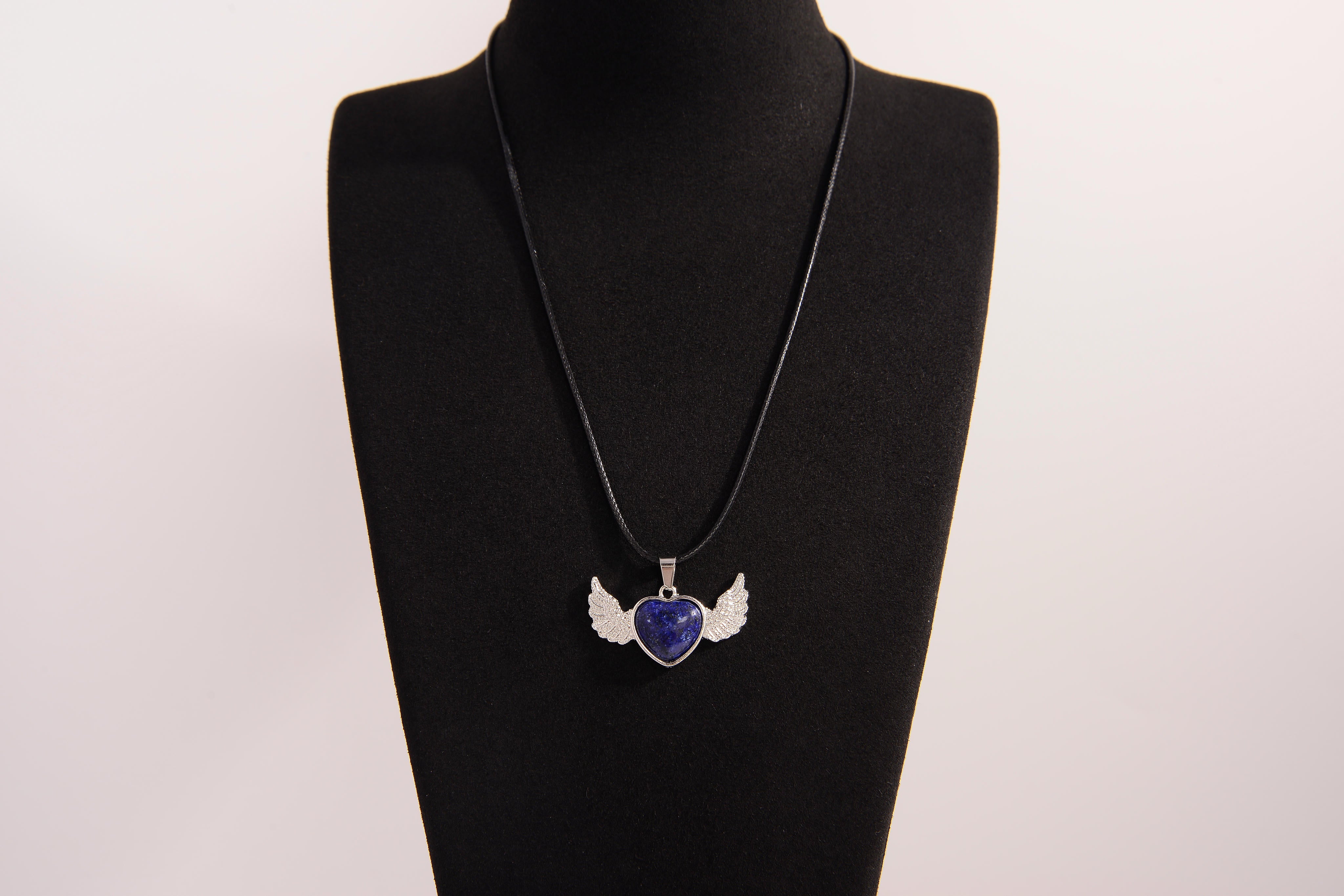 Raw Earth Crystals lapis lazuli heart with wings necklace, featuring a deep blue heart-shaped stone adorned with delicate angelic wings, designed to enhance wisdom, promote self-expression, and support spiritual insight.