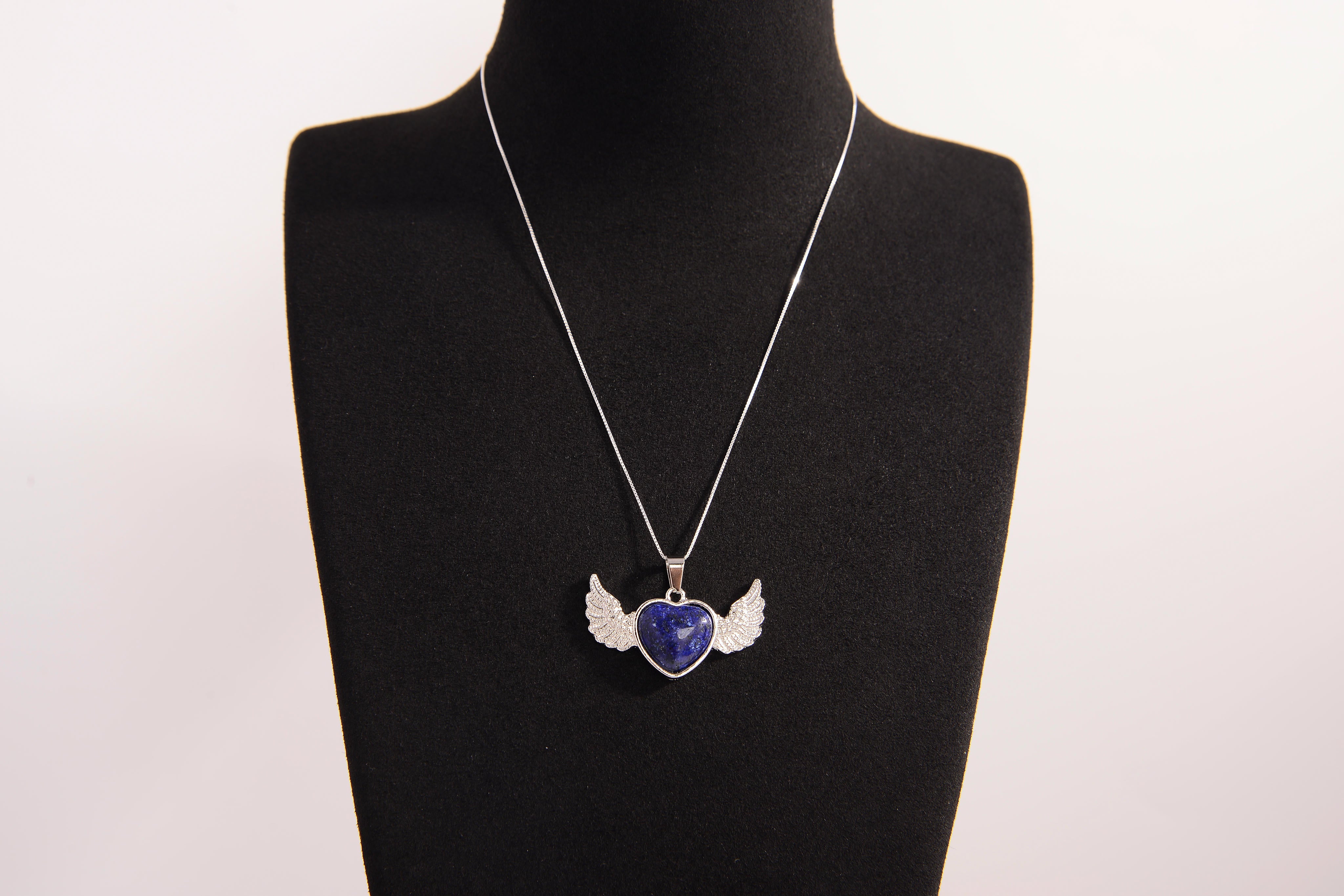 Raw Earth Crystals lapis lazuli heart with wings necklace, featuring a deep blue heart-shaped stone adorned with delicate angelic wings, designed to enhance wisdom, promote self-expression, and support spiritual insight.