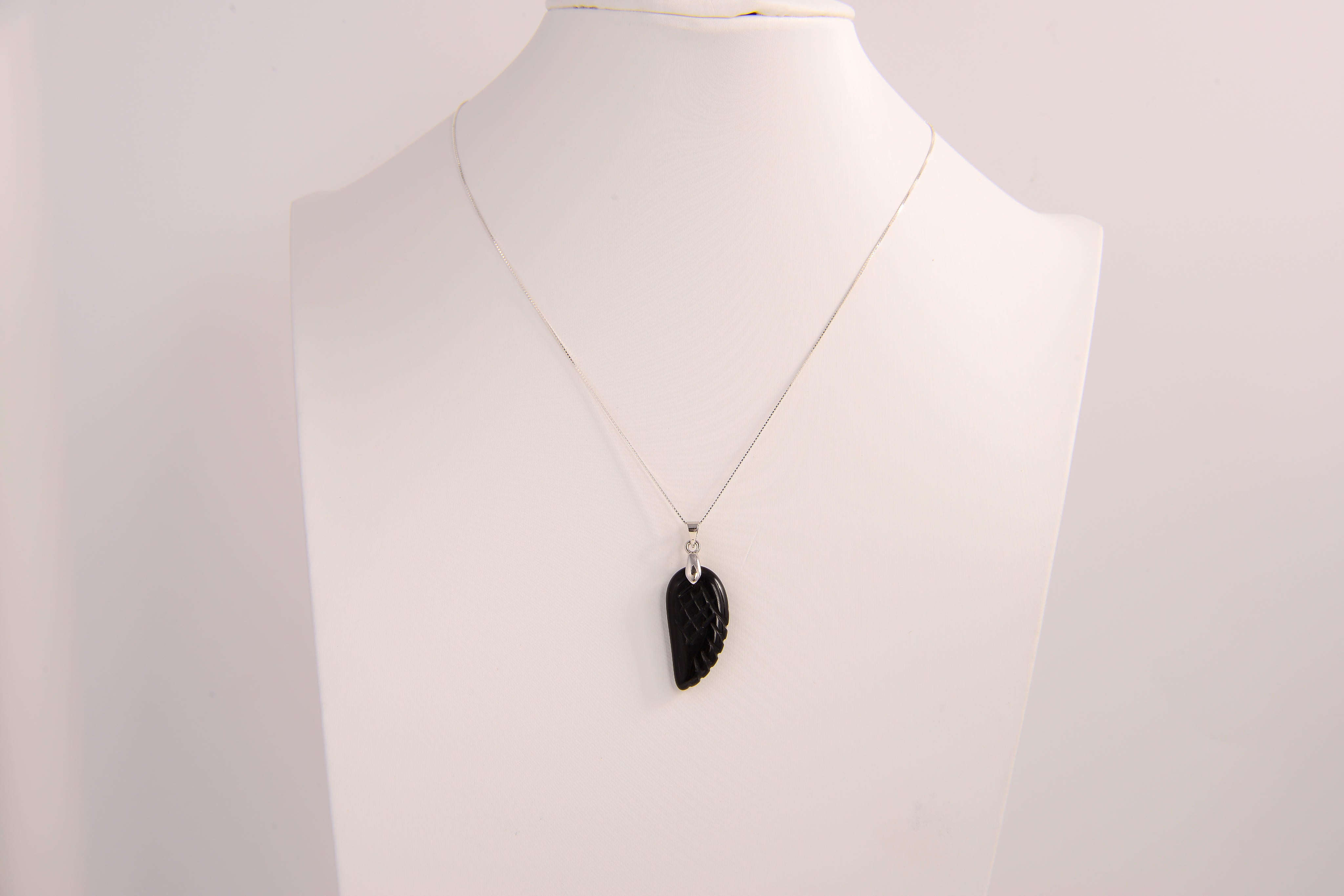 Raw Earth Crystals obsidian angel wing pendant, featuring a polished black obsidian stone carved into an elegant wing shape and set on a silver-tone chain, promoting protection, grounding, and spiritual connection.
