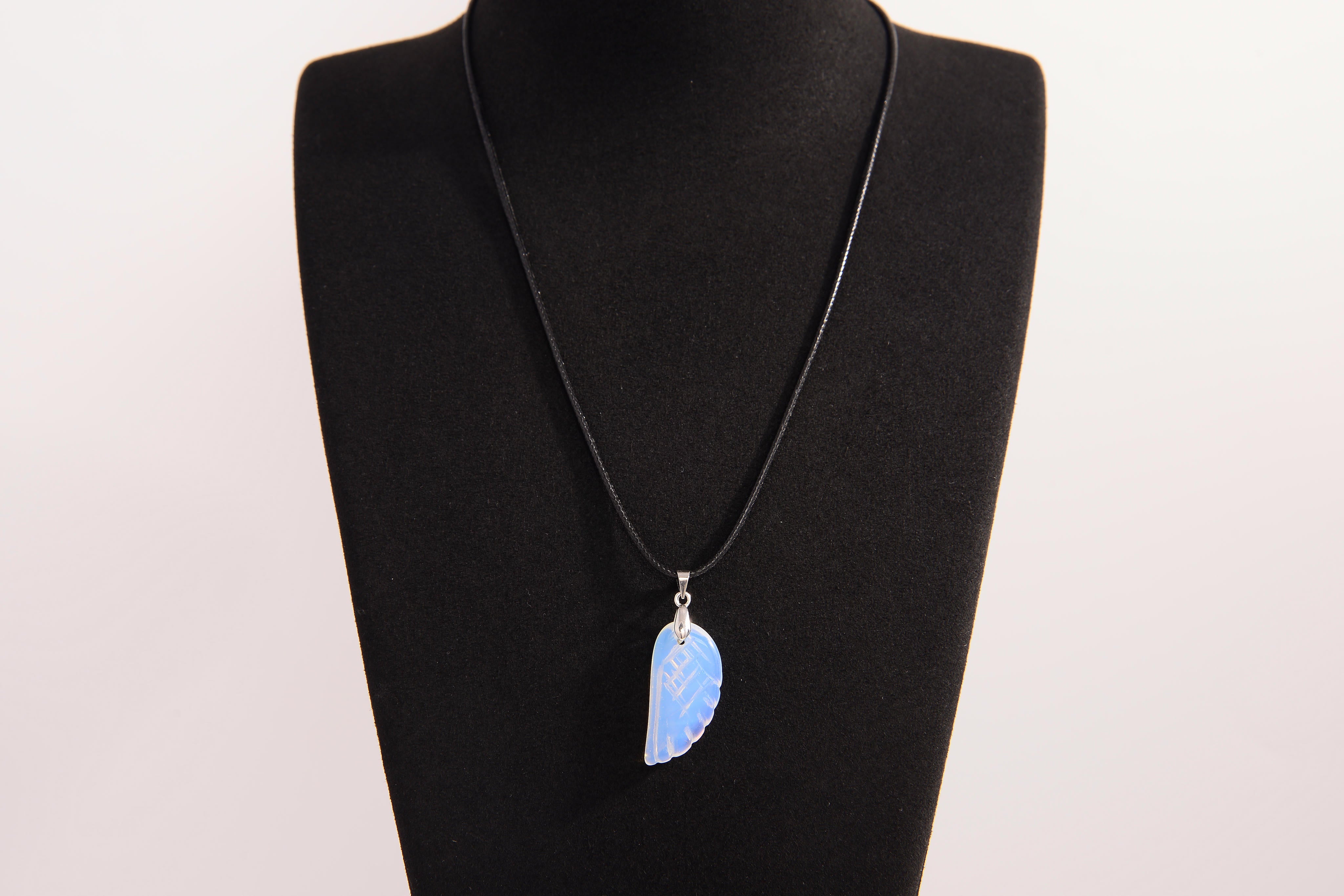 Raw Earth Crystals opalite angel wing pendant, featuring a delicate blue opalite stone carved into an elegant wing shape and set on a silver-tone chain, promoting calmness, spiritual connection, and emotional healing.
