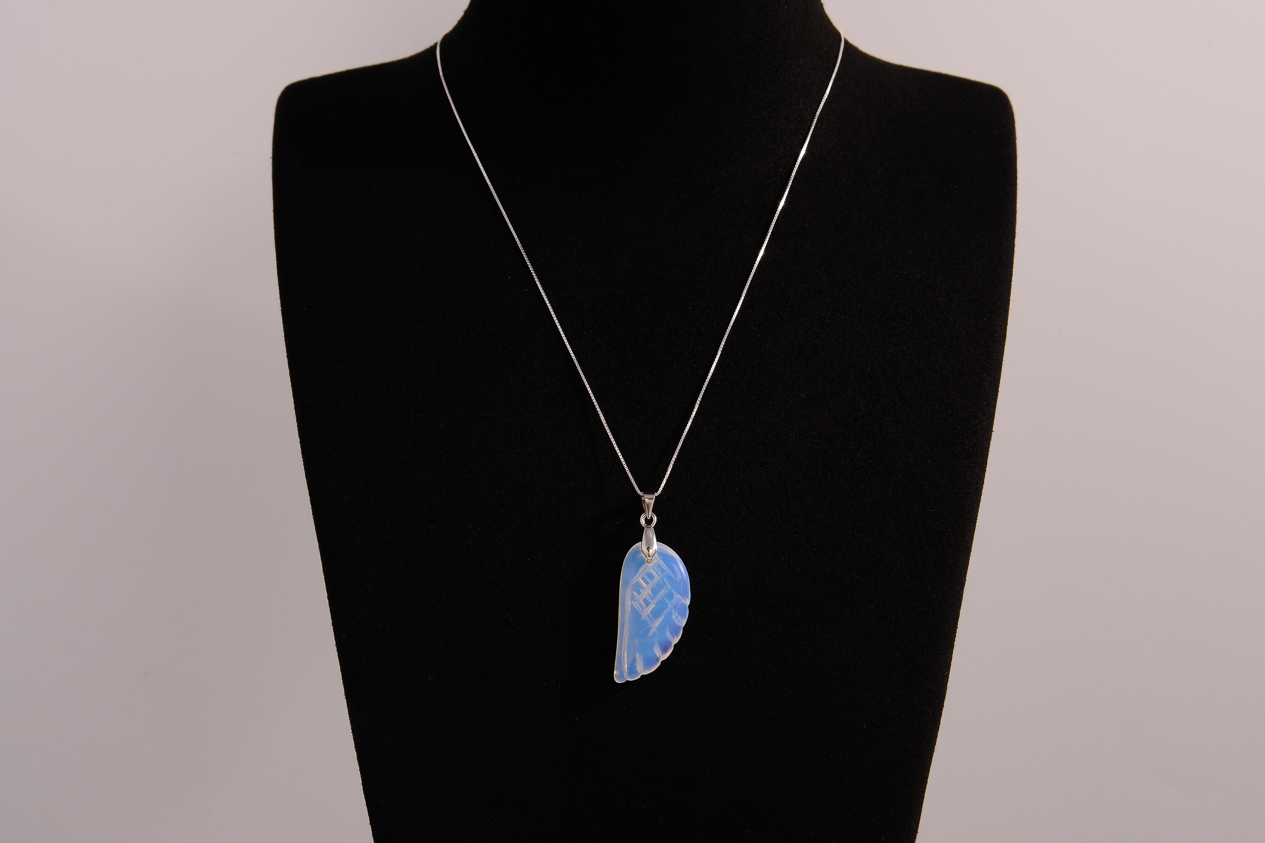 Raw Earth Crystals opalite angel wing pendant, featuring a delicate blue opalite stone carved into an elegant wing shape and set on a silver-tone chain, promoting calmness, spiritual connection, and emotional healing.