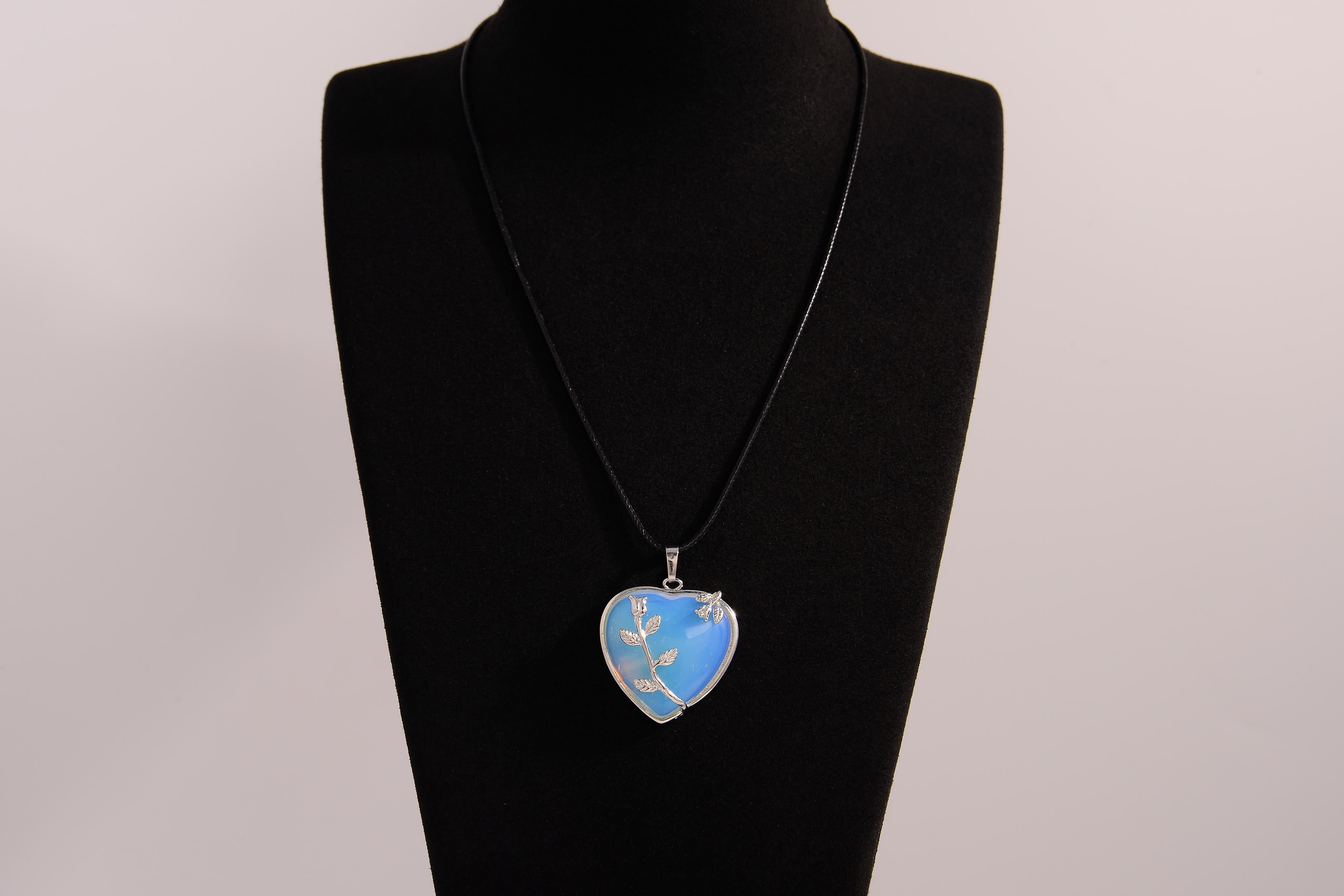 Raw Earth Crystals opalite heart pendant with an elegant rose design, featuring a soft blue opalite stone and a silver-tone vine with leaves, promoting calmness, emotional healing, and spiritual insight.