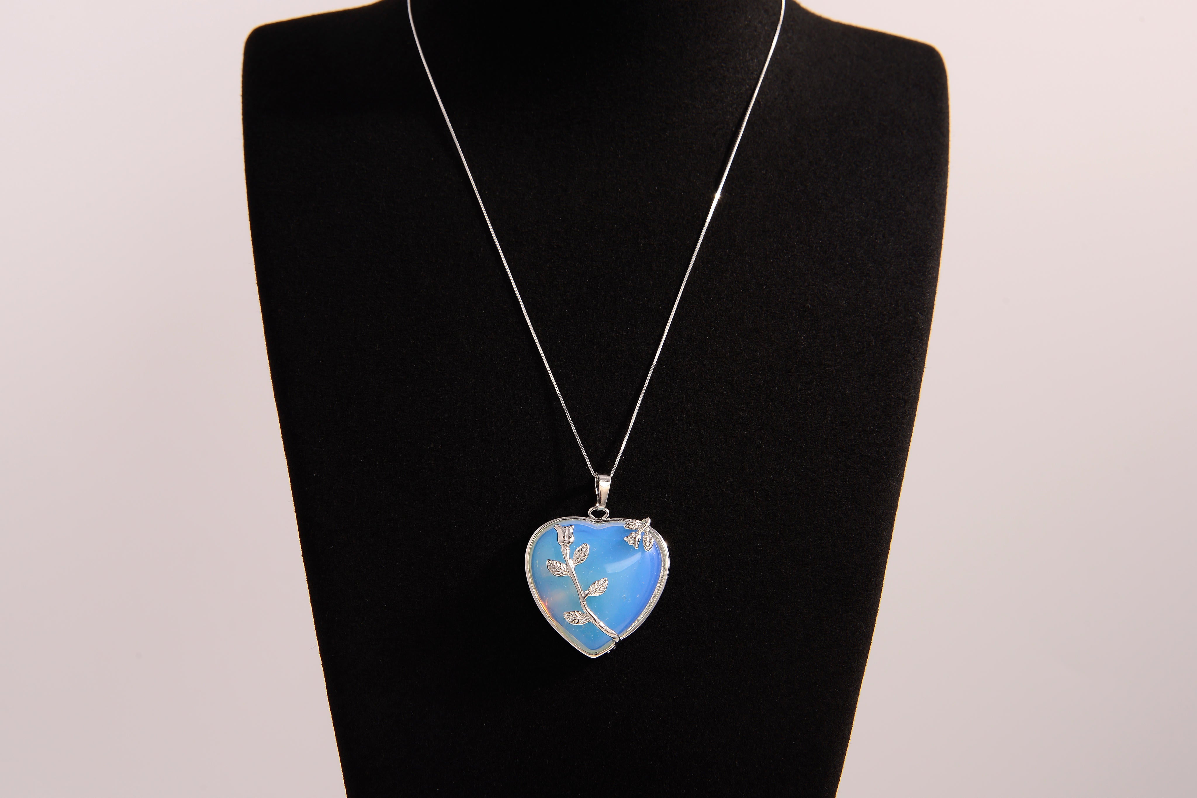 Raw Earth Crystals opalite heart pendant with an elegant rose design, featuring a soft blue opalite stone and a silver-tone vine with leaves, promoting calmness, emotional healing, and spiritual insight.