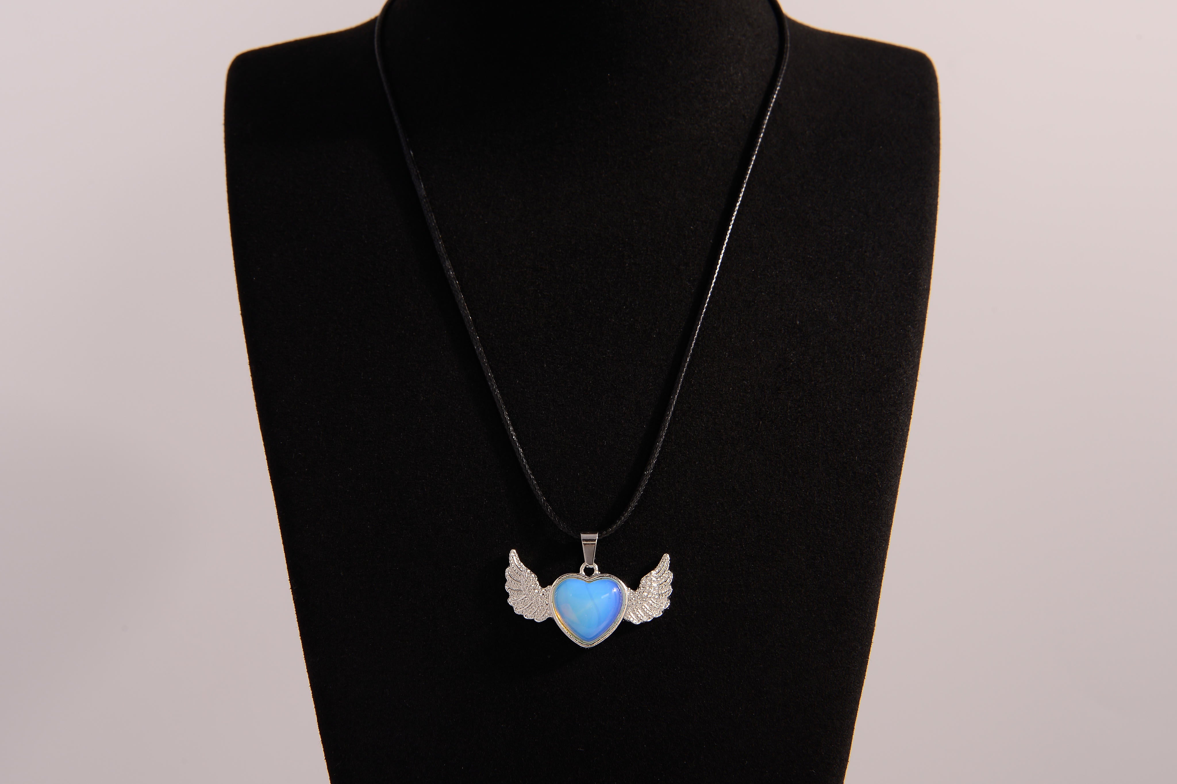 Raw Earth Crystals opalite heart with wings necklace, featuring a luminous blue heart-shaped stone adorned with delicate angelic wings, designed to enhance emotional healing, promote inner peace, and inspire spiritual connection.