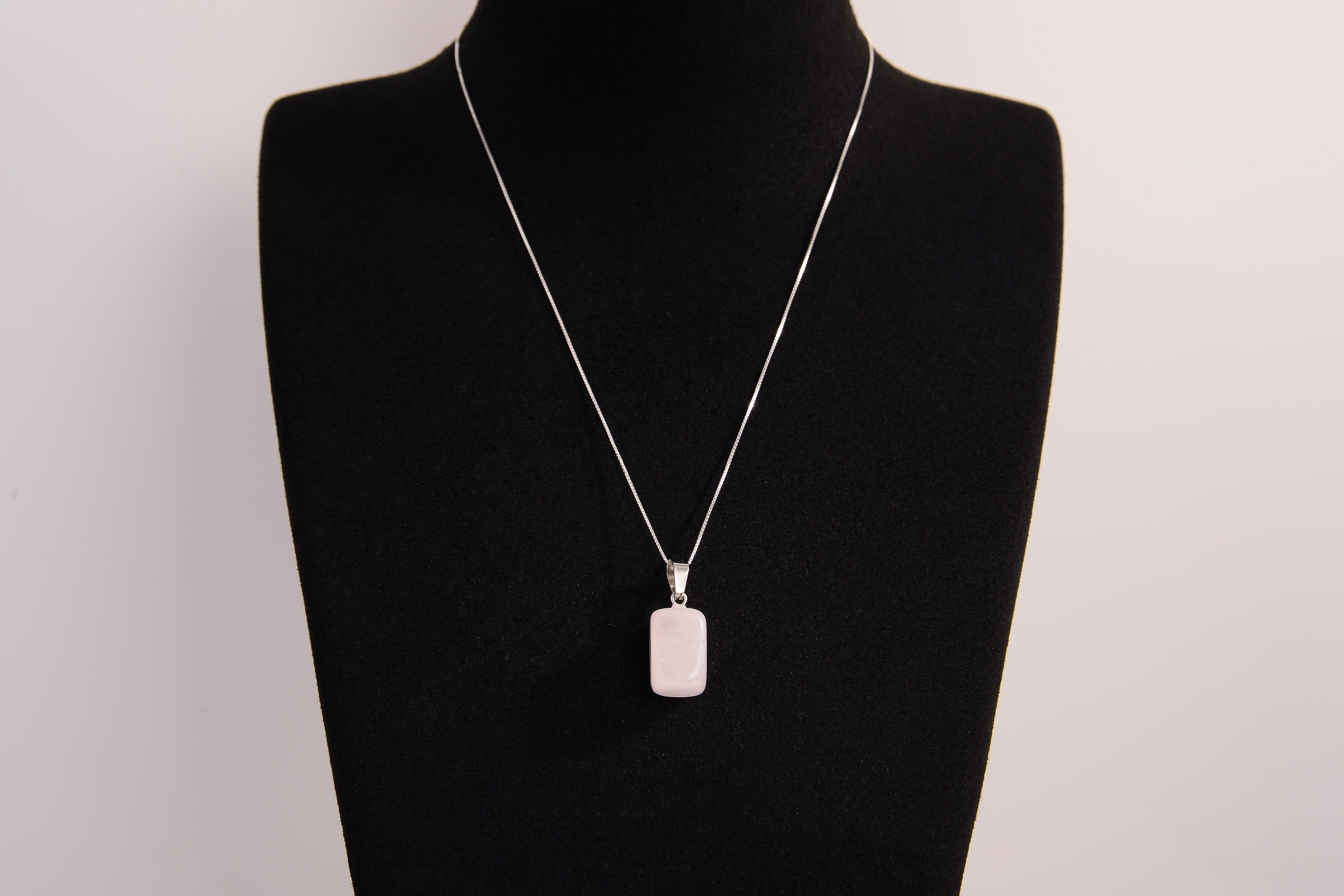 Raw Earth Crystals rectangle pendant featuring a polished rose quartz cabochon set in a sleek silver-toned bail, symbolizing love, compassion, and emotional healing.