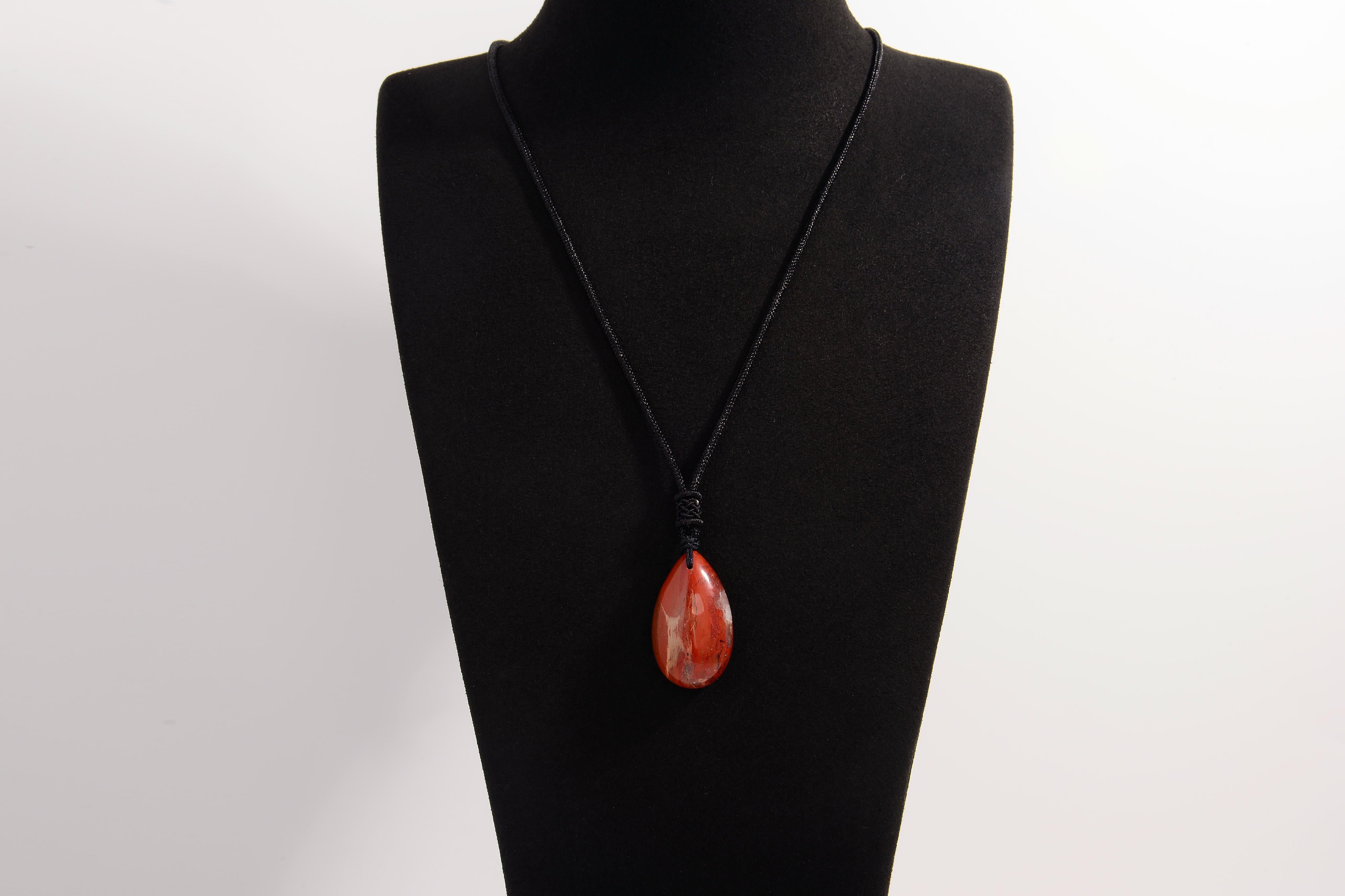 Raw Earth Crystals red jasper teardrop pendant on black cord, made from natural red jasper stone, supporting strength, courage, and emotional balance.