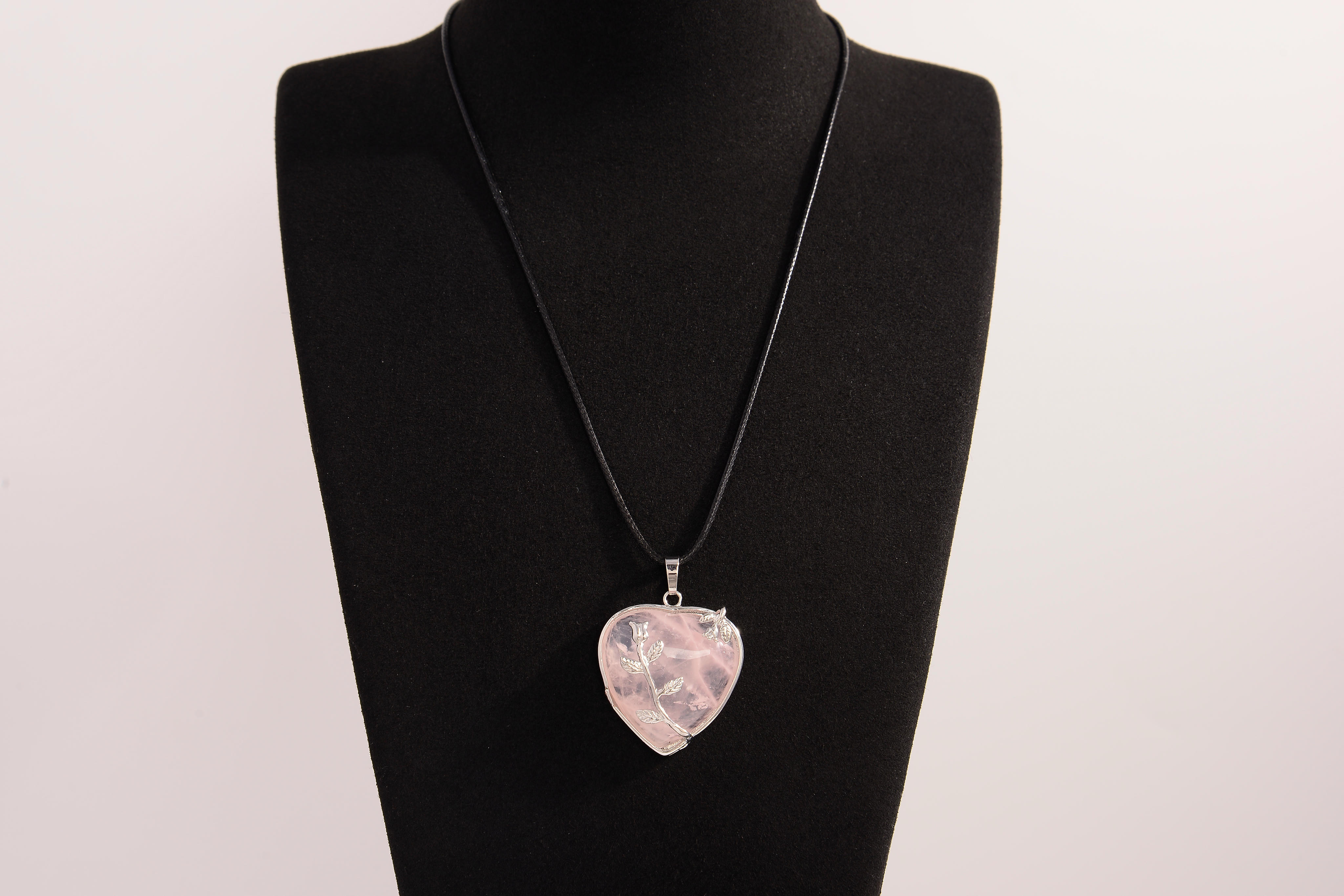 Raw Earth Crystals rose quartz heart pendant with an elegant rose design, featuring a soft pink rose quartz stone and a silver-tone vine with leaves, promoting love, compassion, and emotional healing.