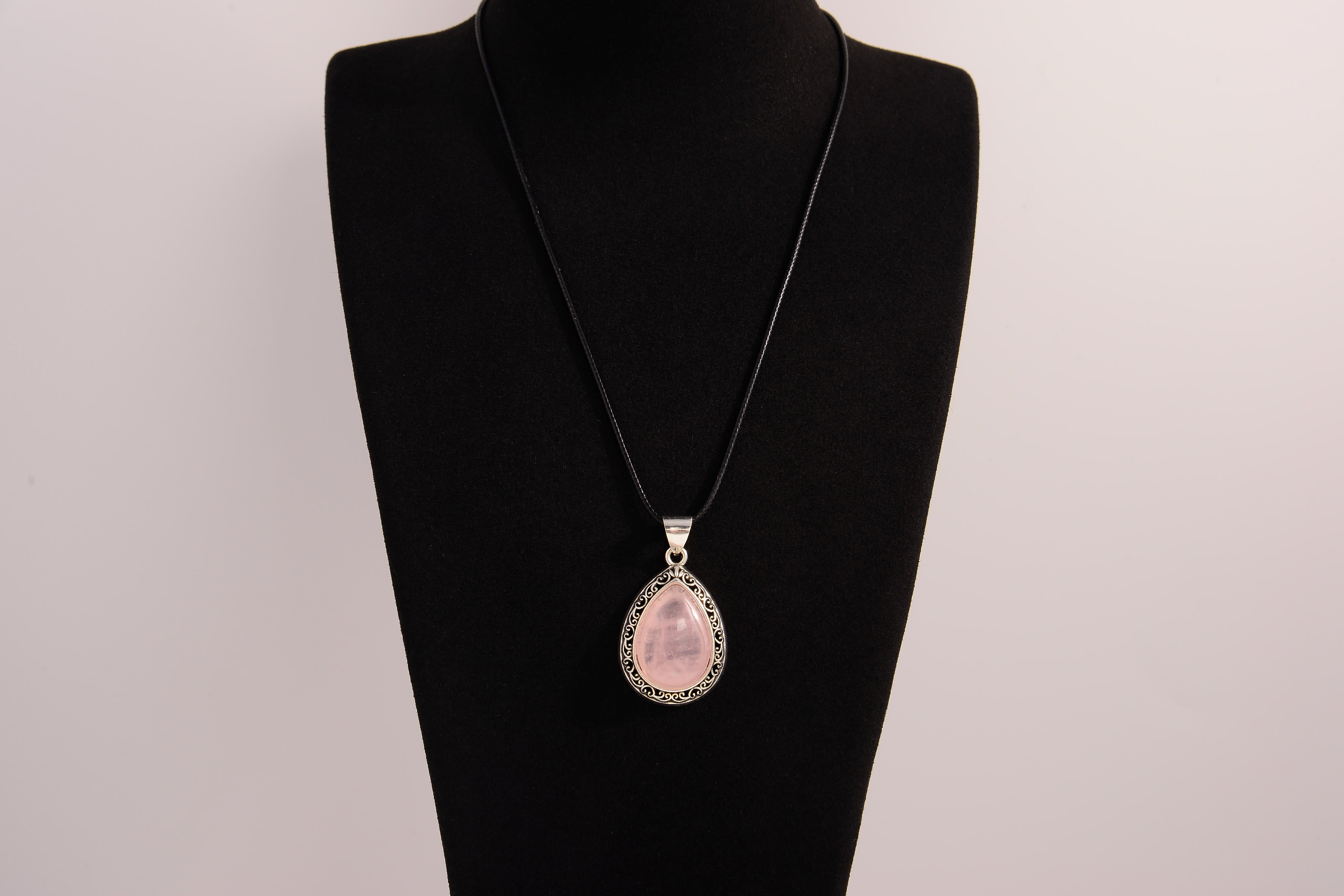 Raw Earth Crystals rose quartz pendant with a teardrop-shaped design, featuring natural rose quartz and an ornate silver-tone setting, promoting love, compassion, and emotional healing.