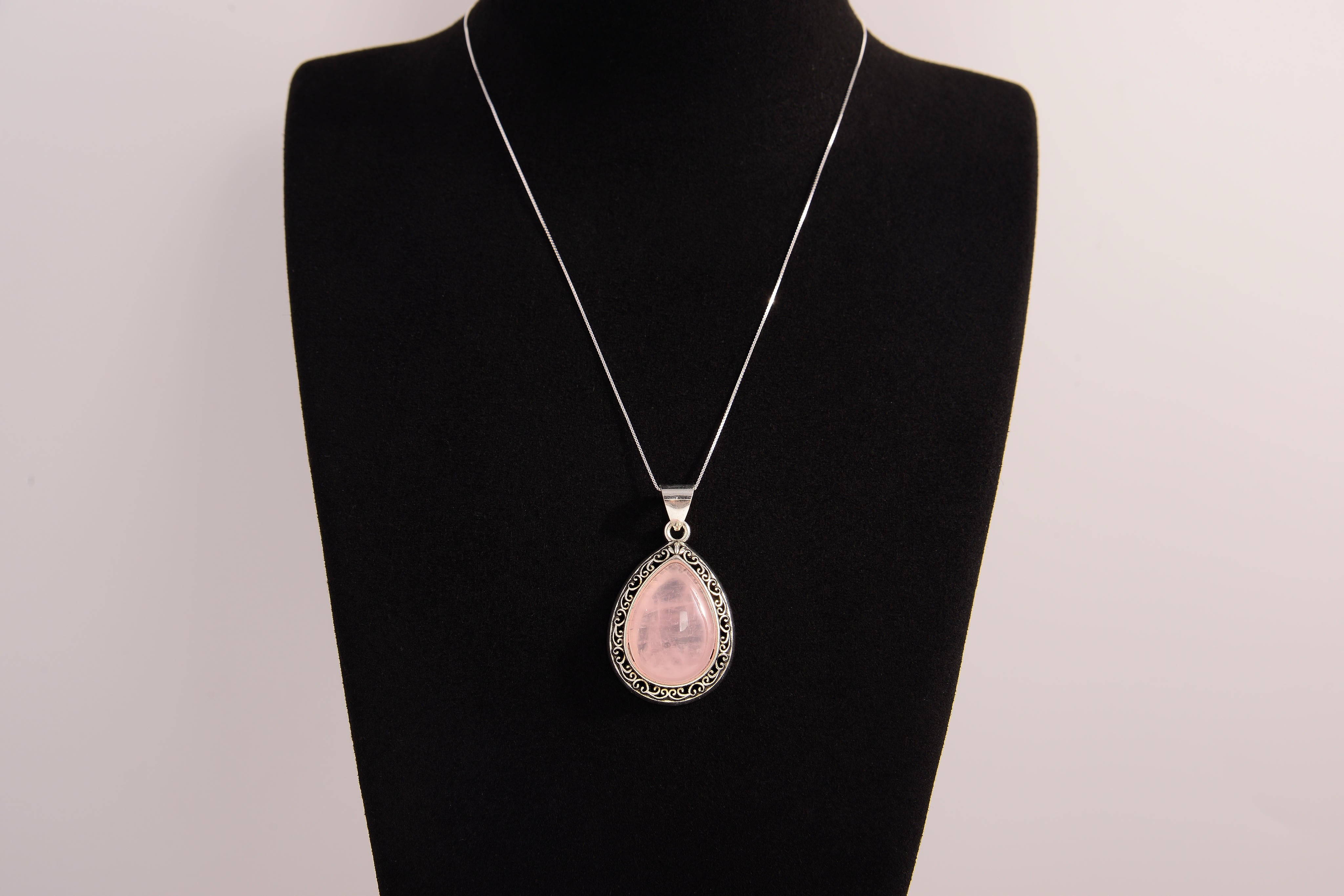 Raw Earth Crystals rose quartz pendant with a teardrop-shaped design, featuring natural rose quartz and an ornate silver-tone setting, promoting love, compassion, and emotional healing.
