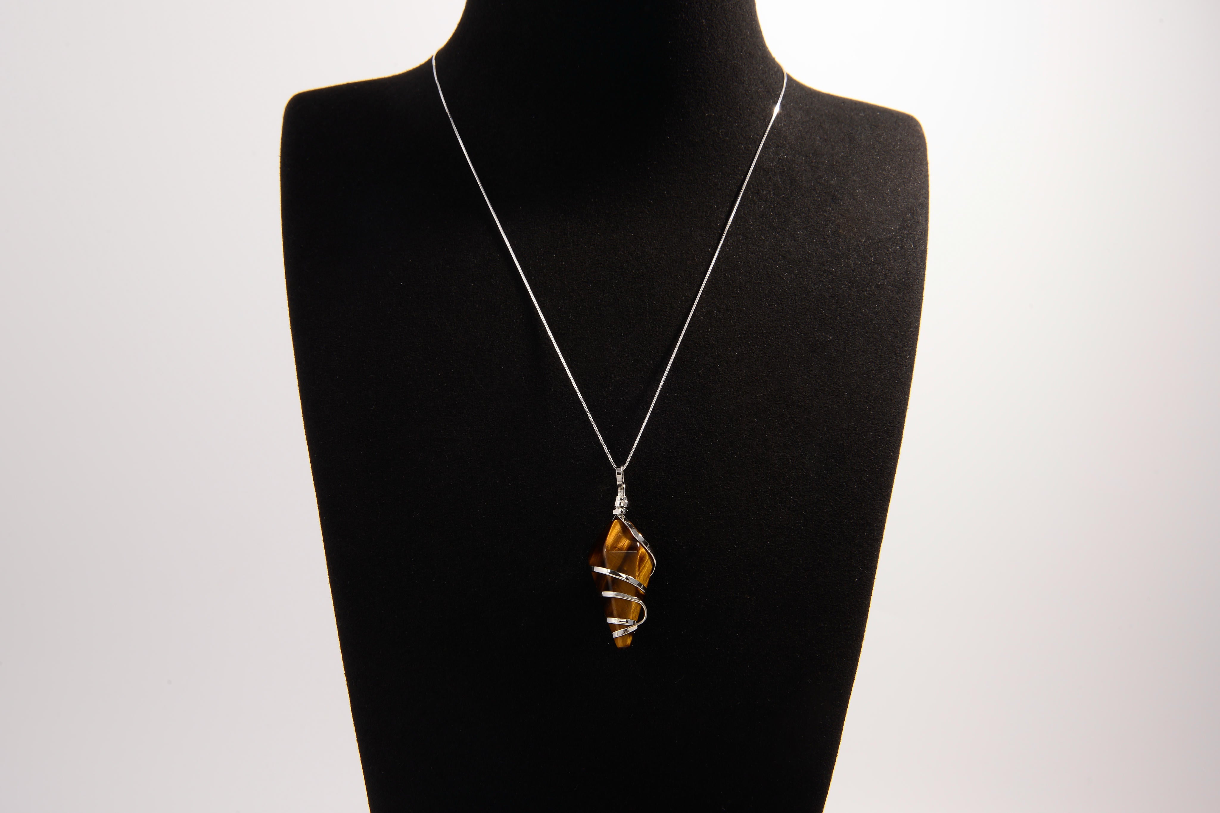 Raw Earth Crystals tiger eye pendant with a spiral wire wrap design, crafted from natural stone to promote confidence, protection, and grounding energy.