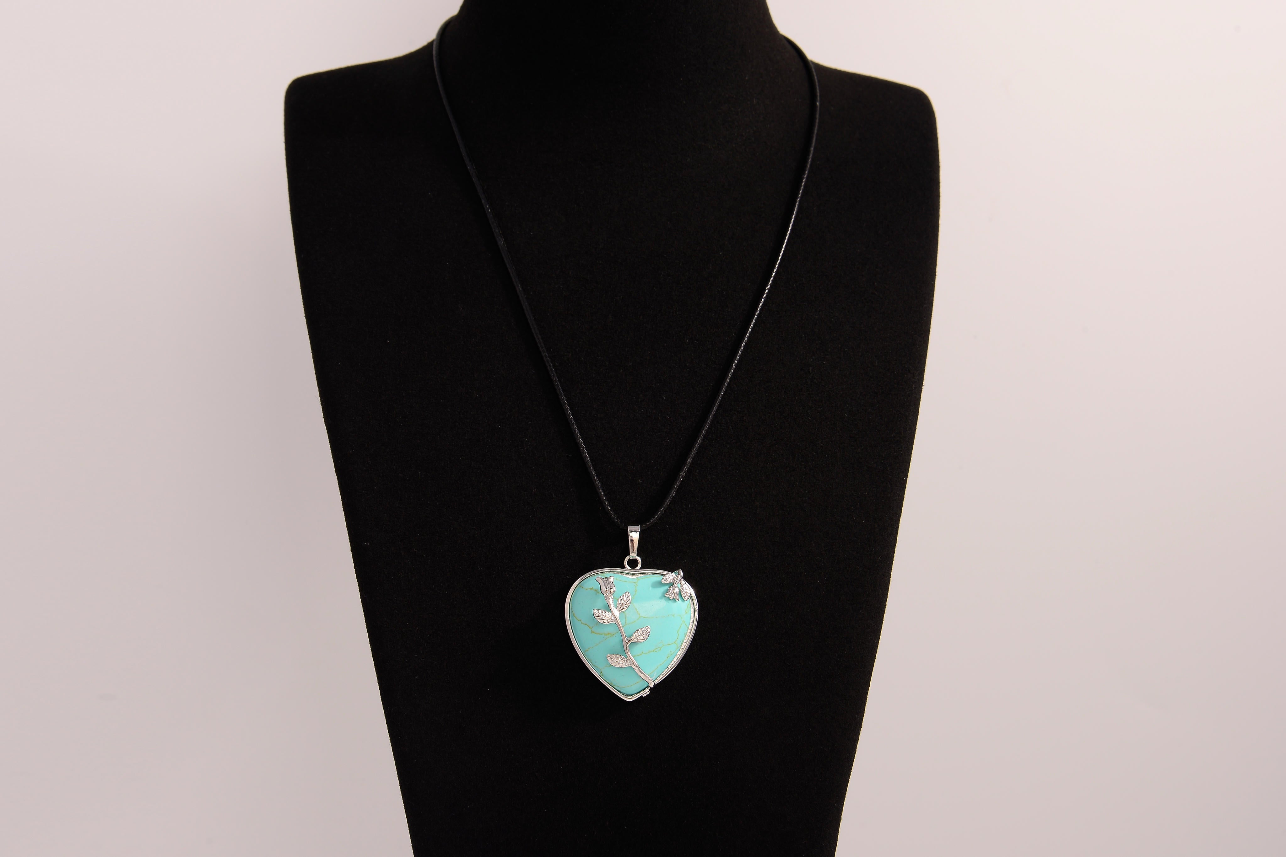 Raw Earth Crystals turquoise heart pendant with an elegant rose design, featuring a vibrant turquoise stone and a silver-tone vine with leaves, promoting communication, creativity, and emotional balance.