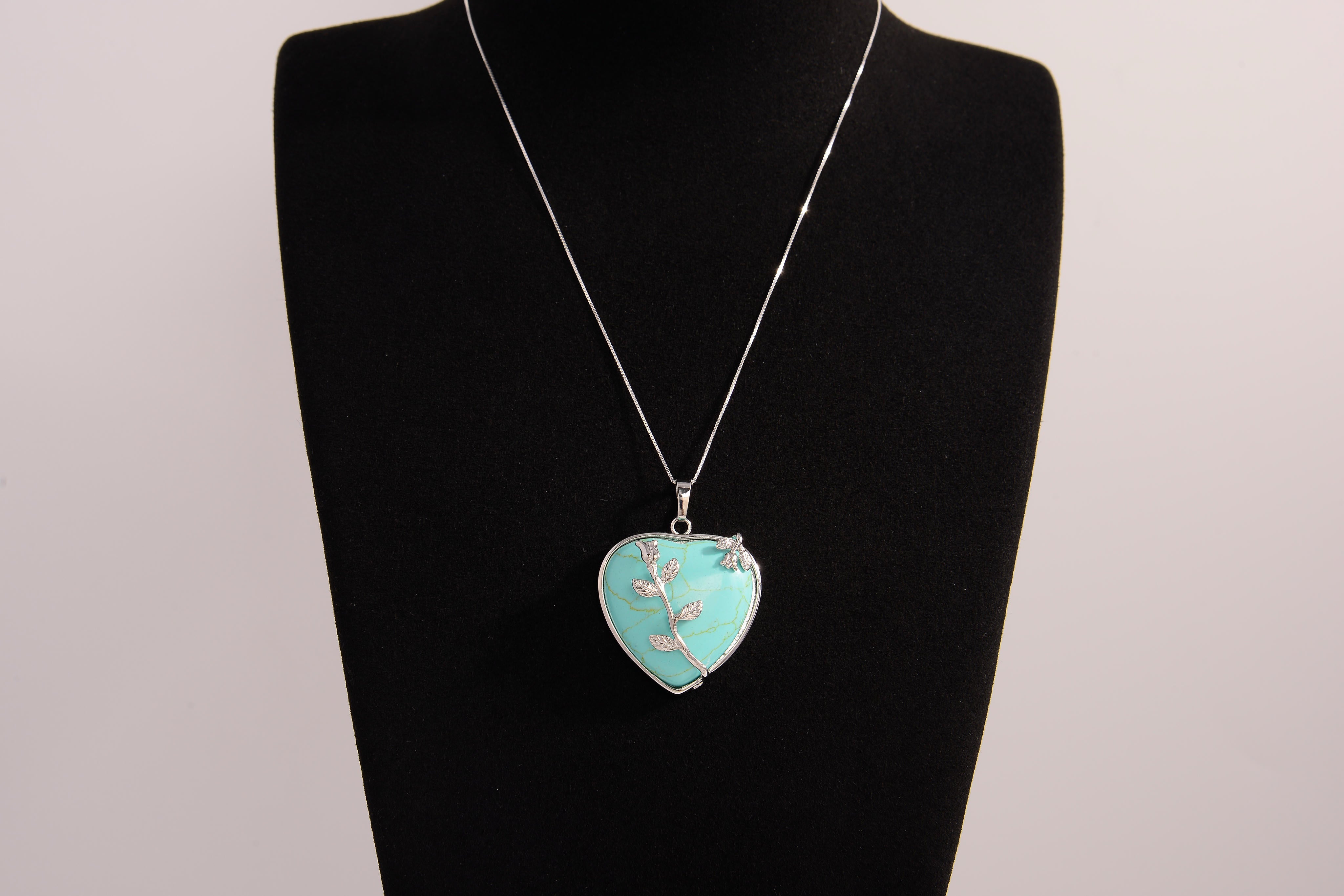 Raw Earth Crystals turquoise heart pendant with an elegant rose design, featuring a vibrant turquoise stone and a silver-tone vine with leaves, promoting communication, creativity, and emotional balance.