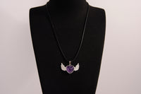 Raw Earth Crystals amethyst heart with wings necklace, featuring a deep purple heart-shaped stone adorned with delicate angelic wings, designed to enhance intuition, promote spiritual growth, and support inner peace.