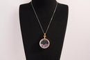 Raw Earth Crystals amethyst pendant with a crystal-encased design, featuring natural amethyst and gold-tone setting, enhancing intuition, calmness, and spiritual awareness.