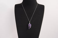 Raw Earth Crystals amethyst pendant featuring an etched design, crafted from natural stone to enhance spiritual awareness, calm the mind, and support emotional balance.