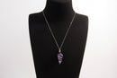 Raw Earth Crystals amethyst pendant with a spiral wire wrap design, crafted from natural stone to support spiritual growth, intuition, and inner peace.