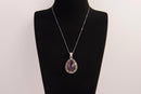 Raw Earth Crystals amethyst pendant with a teardrop-shaped design, featuring natural amethyst and an ornate silver-tone setting, promoting spiritual growth, calmness, and intuition.