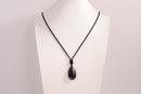 Raw Earth Crystals amethyst teardrop pendant on black cord, made from natural amethyst stone, supporting spiritual growth, calmness, and intuitive clarity.
