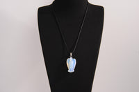 Raw Earth Crystals angel pendant crafted from carved opalite, featuring a soft, milky blue iridescence to promote calmness, emotional healing, and spiritual clarity.