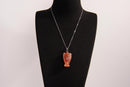 Raw Earth Crystals angel pendant crafted from carved red agate, featuring a warm, translucent design to promote courage, emotional strength, and grounding energy.