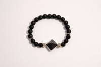 Raw Earth Crystals black onyx and black tourmaline bracelet with silver accent, crafted from natural crystals, promotes protection, grounding, and spiritual clarity.