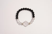 Raw Earth Crystals black onyx and clear quartz bracelet with silver accent, crafted from natural crystals, promotes clarity, protection, and spiritual alignment.