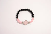 Raw Earth Crystals black onyx and pink quartz bracelet with silver accent, crafted from natural crystals, promotes emotional balance, love, and inner peace.