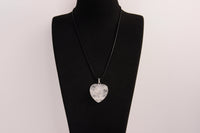Raw Earth Crystals clear quartz heart pendant with an elegant rose design, featuring a delicate silver-tone stem and leaves embedded in natural clear quartz, promoting clarity, love, and spiritual connection.