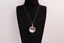 Raw Earth Crystals clear quartz pendant with a crystal-encased design, featuring natural clear quartz and gold-tone setting, enhancing clarity, healing, and spiritual connection.