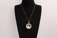 Raw Earth Crystals clear quartz pendant with a crystal-encased design, featuring natural clear quartz and gold-tone setting, enhancing clarity, healing, and spiritual connection.