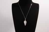 Raw Earth Crystals clear quartz pendant with a spiral wire wrap design, crafted from natural stone to enhance clarity, focus, and spiritual energy.
