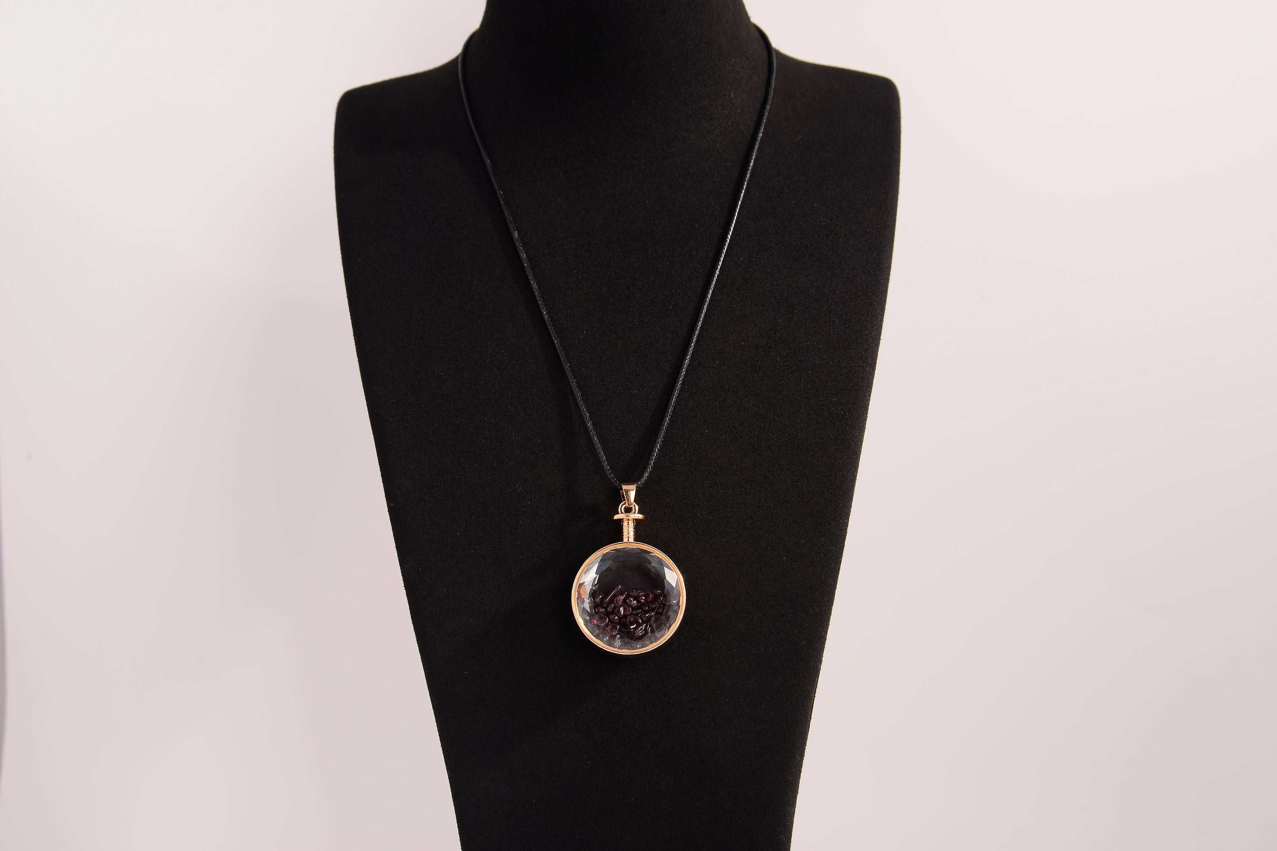 Raw Earth Crystals garnet pendant with a crystal-encased design, featuring natural garnet and gold-tone setting, promoting passion, vitality, and emotional strength.