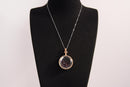 Raw Earth Crystals garnet pendant with a crystal-encased design, featuring natural garnet and gold-tone setting, promoting passion, vitality, and emotional strength.