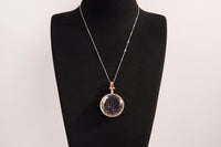 Raw Earth Crystals garnet pendant with a crystal-encased design, featuring natural garnet and gold-tone setting, promoting passion, vitality, and emotional strength.