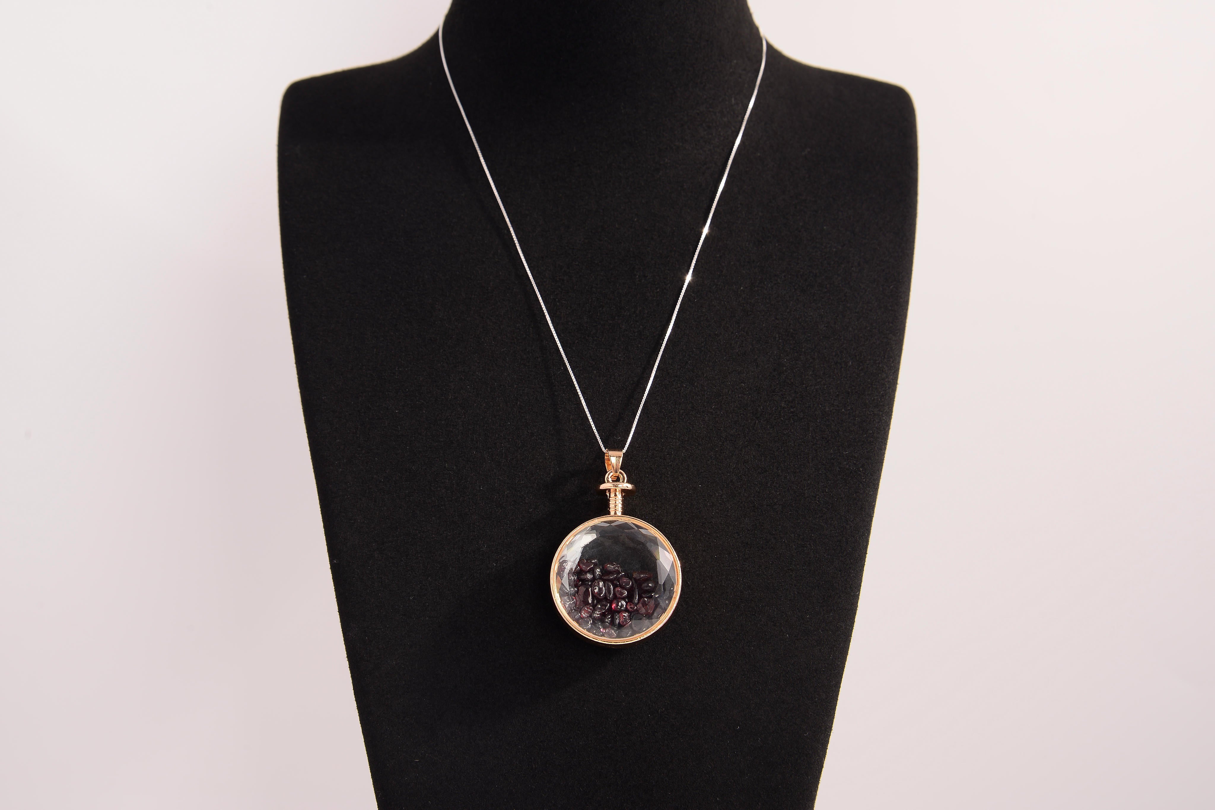Raw Earth Crystals garnet pendant with a crystal-encased design, featuring natural garnet and gold-tone setting, promoting passion, vitality, and emotional strength.