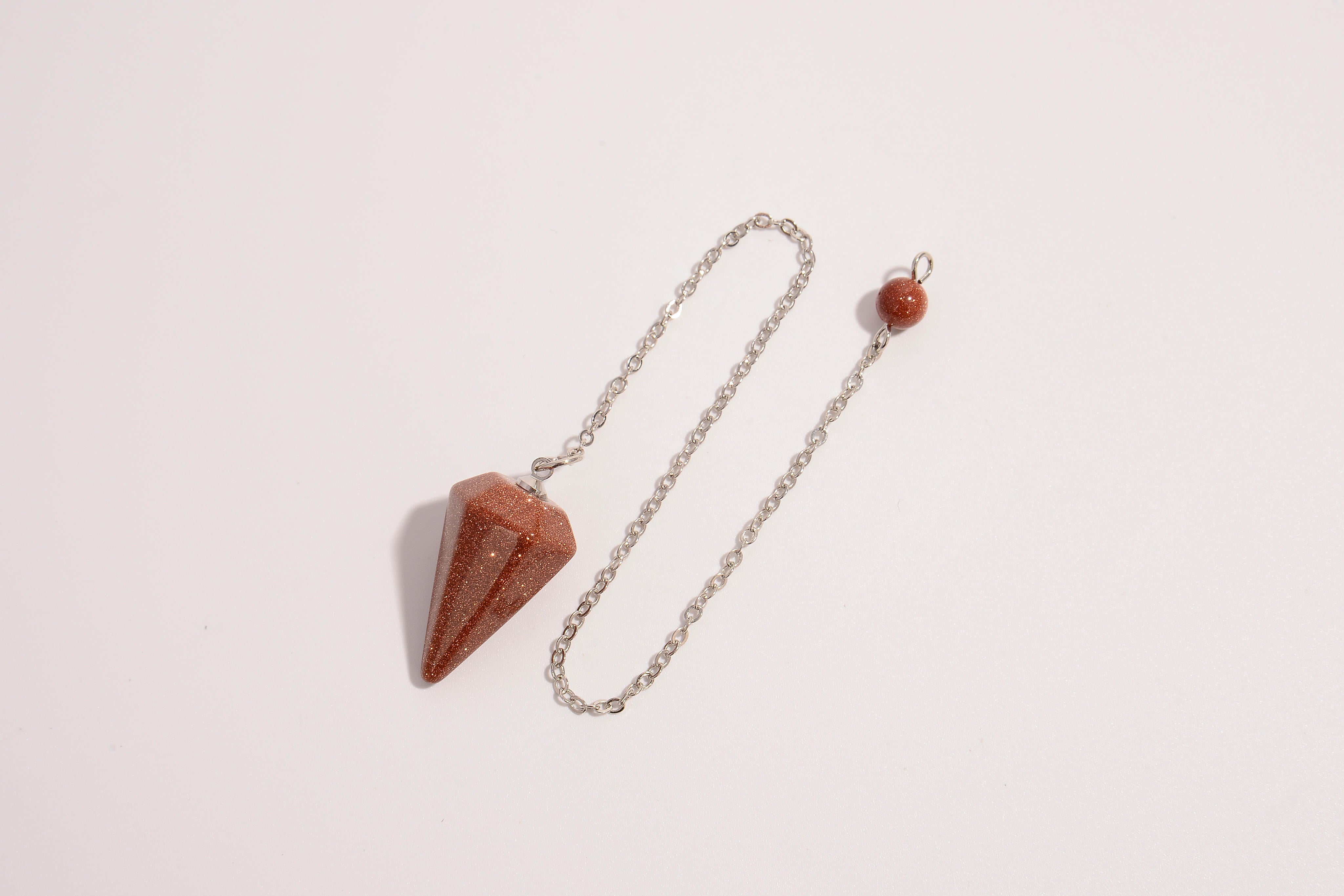 Raw Earth Crystals golden quartz pendulum with pointed crystal and silver chain, designed for manifestation, abundance, and energetic clarity.