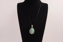 Raw Earth Crystals green aventurine pendant with a teardrop-shaped design, featuring natural green aventurine and an ornate silver-tone setting, promoting prosperity, luck, and emotional balance.