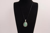 Raw Earth Crystals green aventurine pendant with a teardrop-shaped design, featuring natural green aventurine and an ornate silver-tone setting, promoting prosperity, luck, and emotional balance.