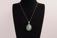 Raw Earth Crystals green aventurine pendant with a teardrop-shaped design, featuring natural green aventurine and an ornate silver-tone setting, promoting prosperity, luck, and emotional balance.